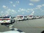 Police cars were among emergency vehicles that greeted the flight carrying the body of Col. Tomas DeLeon at Miami International Airport. 