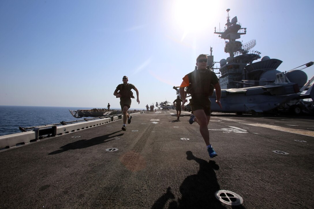 Lance Cpls. Justin M. Corduan, right, and Tyler J. Potter, left,  machinegunners with Fox Company, Battalion Landing Team 2nd Battalion, 1st Marines (BLT 2/1), 11th Marine Expeditionary Unit (MEU), and San Diego and Mount Washington, Kentucky natives (respectively), perform sprints with body armor aboard the USS Makin Island (LHD 8), Oct. 7. Marines with the 11th MEU are deployed with the Makin island Amphibious Ready Group as a flexible, adaptable and persistent force in the U.S. 5th Fleet area of responsibility. (U.S. Marine Corps photo by Cpl. Demetrius Morgan/RELEASED)