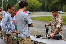 Gunnery Sgt. Dominic Chavez, an Explosive Ordnance Disposal Technician with Explosive Ordnance Disposal Company, 8th Engineer Support Battalion, 2nd Marine Logistics Group, and a native of Albuquerque, explains how robotics has made his life easier with a prosthetic leg, Oct. 3, 2014, aboard Camp Lejeune, N.C.  Approximately 60 students, ranging from freshmen to seniors, packed the classroom to hear how the Marines use robotics on the battlefield and how engineering can better peoples lives. The school requested the Marines give the demonstration because the students are beginning their robotics curriculum of the Bio-Tech Department course of study. (U.S. Marine Corps photo by Cpl. Michael Dye / Released)