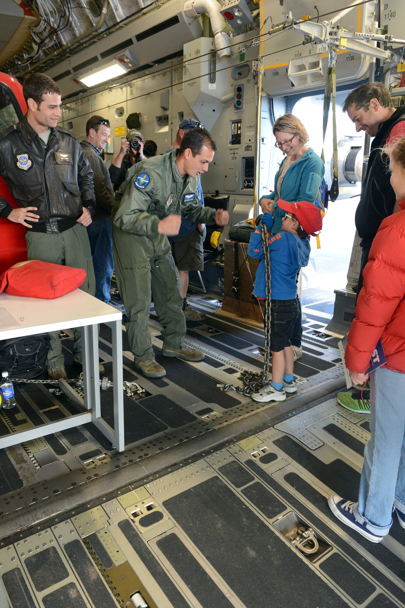 Staff Sgt. Kermit Maronge  helps a young New Zealand child try to lift up an MB2 tie-down chain on the C-17 Globemaster III, Oct. 5, 2014, as part of the U.S. Antarctic Program Day for IceFest 2014 at Christchurch, New Zealand. The chain weighs approximately 33 pounds and throughout the day the loadmasters let the children try and lift it. Maronge is a loadmaster with the 304th Expeditionary Airlift Squadron and 7th Airlift Squadron. (U.S. Air Force photo/Master Sgt. Todd Wivell)
