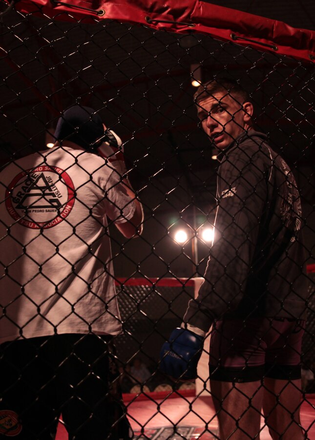 John Zimmer (right), a security specialist at Headquarters Battalion, Marine Forces Reserve, stands in the octagon minutes before his fight at the Caged Warrior Championship V on Oct. 4th, 2014, in Patterson, La. This was Zimmer’s first time competing in a mixed martial arts fight.
