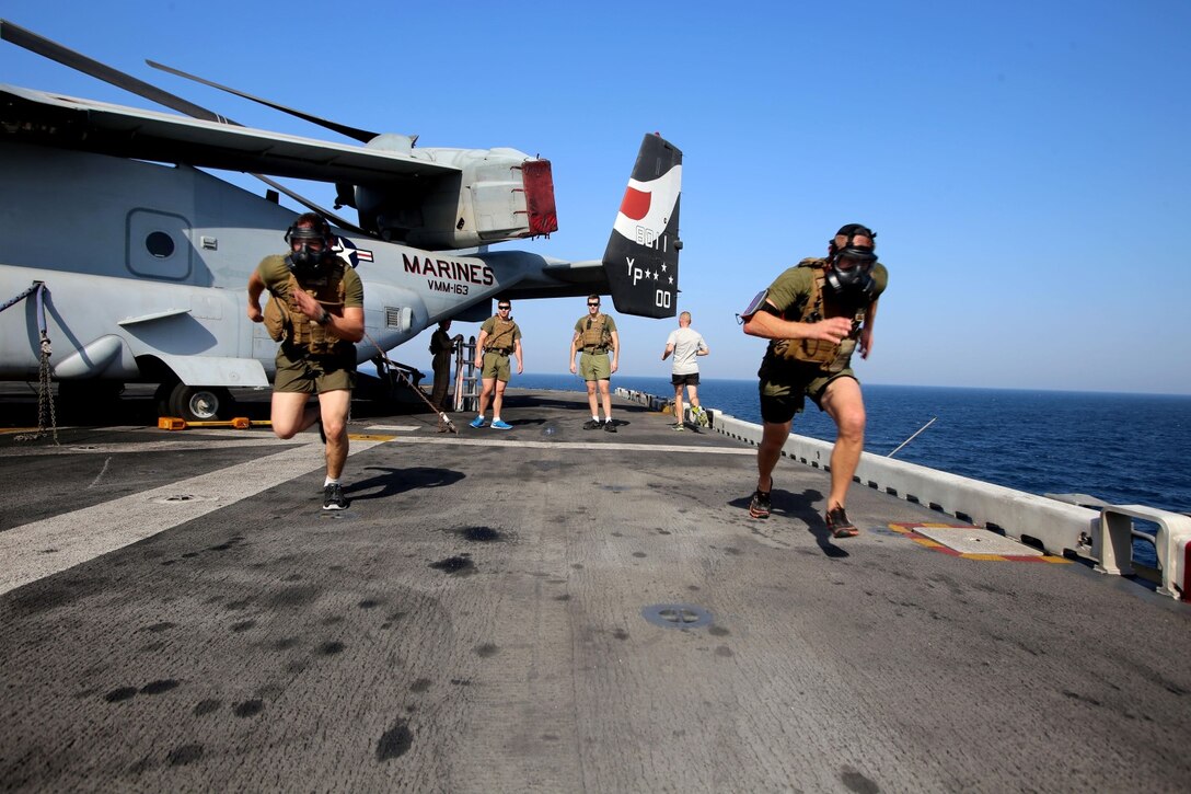 Marines with the 11th Marine Expeditionary Unit perform sprints with gas masks aboard the USS Makin Island Oct. 7, 2014. The 11th MEU is deployed with the Makin Island Amphibious Ready Group as a theater reserve and crisis response force throughout U.S. Central Command and the U.S 5th Fleet area of responsibility.
