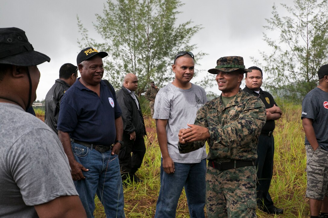 U.S. Marine Staff Sgt. Milton Donatus, second from right, speaks with Palau national law enforcement officers during live-fire training with the M9A1 9 mm service pistol Sept. 16 in Irai, Palau. Donatus, from Ngaraard, Palau, led the training and taught his fellow Palauans the fundamentals of combat marksmanship with the weapon. The training is part of exercise T-AKE 14-2, a maritime pre-positioned force, multi-country theater security cooperation event that deploys from Okinawa aboard the USNS Sacagawea to conduct training exercises. Donatus is the training chief with Combat Logistics Detachment 379, Combat Logistics Regiment 37, 3rd Marine Logistics Group, III Marine Expeditionary Force. (U.S. Marine Corps photo by Lance Cpl. Drew Tech/Released)