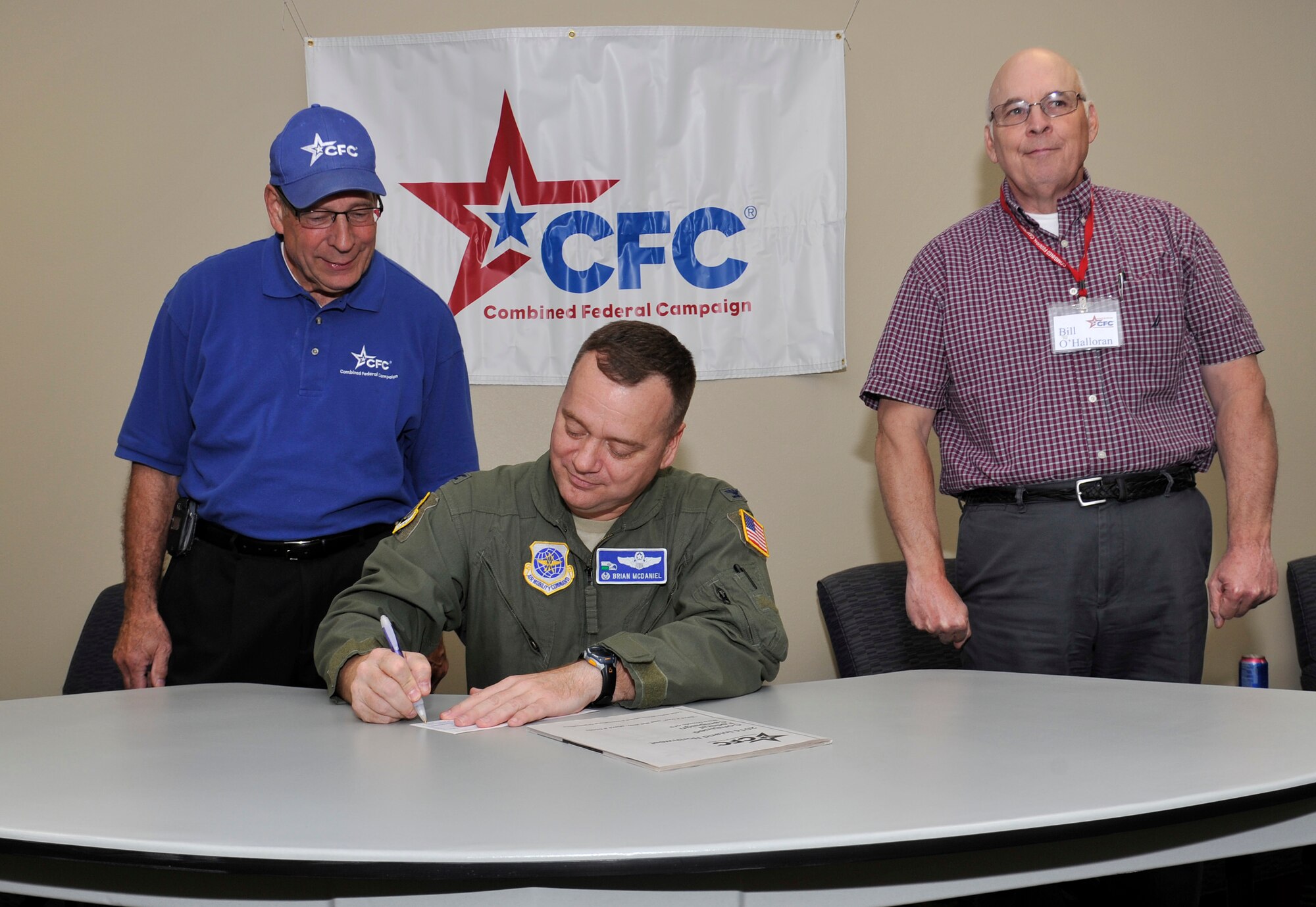 Col. Brian McDaniel, 92nd Air Refueling Wing commander, signs a combined federal campaign donation form with John Guilbeault, CFC manager, and Bill OHalloran, CFC account manager, in the Red Morgan Center at Fairchild Air Force Base, Wash., Oct. 6, 2014. The mission of the CFC is to promote and support philanthropy through a program that is employee focused, cost-efficient and effective in providing all federal employees the opportunity to improve the quality of life for all. (U.S. Air Force photo by Senior Airman Ryan Zeski)
