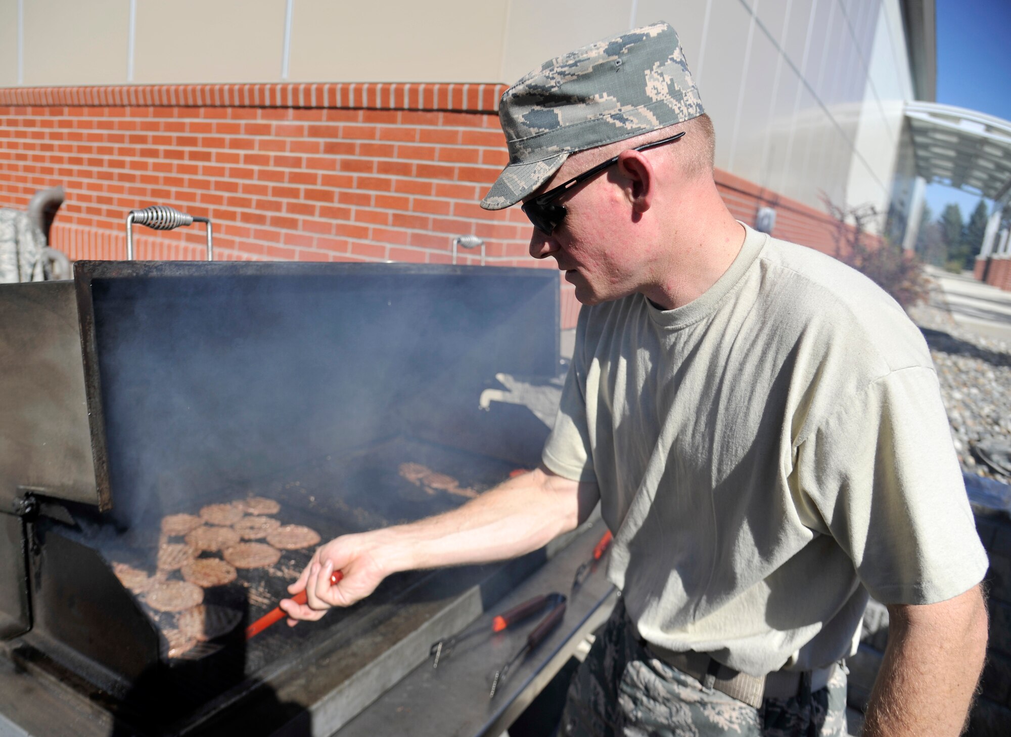 Master Sgt. Jeremy Dyess, 92nd Maintenance Squadron flight chief, cooks burgers for the Combined Federal Campaign burger burn outside the Red Morgan Center at Fairchild Air Force Base, Wash., Oct. 6, 2014. The burger burn event is held each year to initiate the start of the campaign. (U.S. Air Force photo by Senior Airman Ryan Zeski)