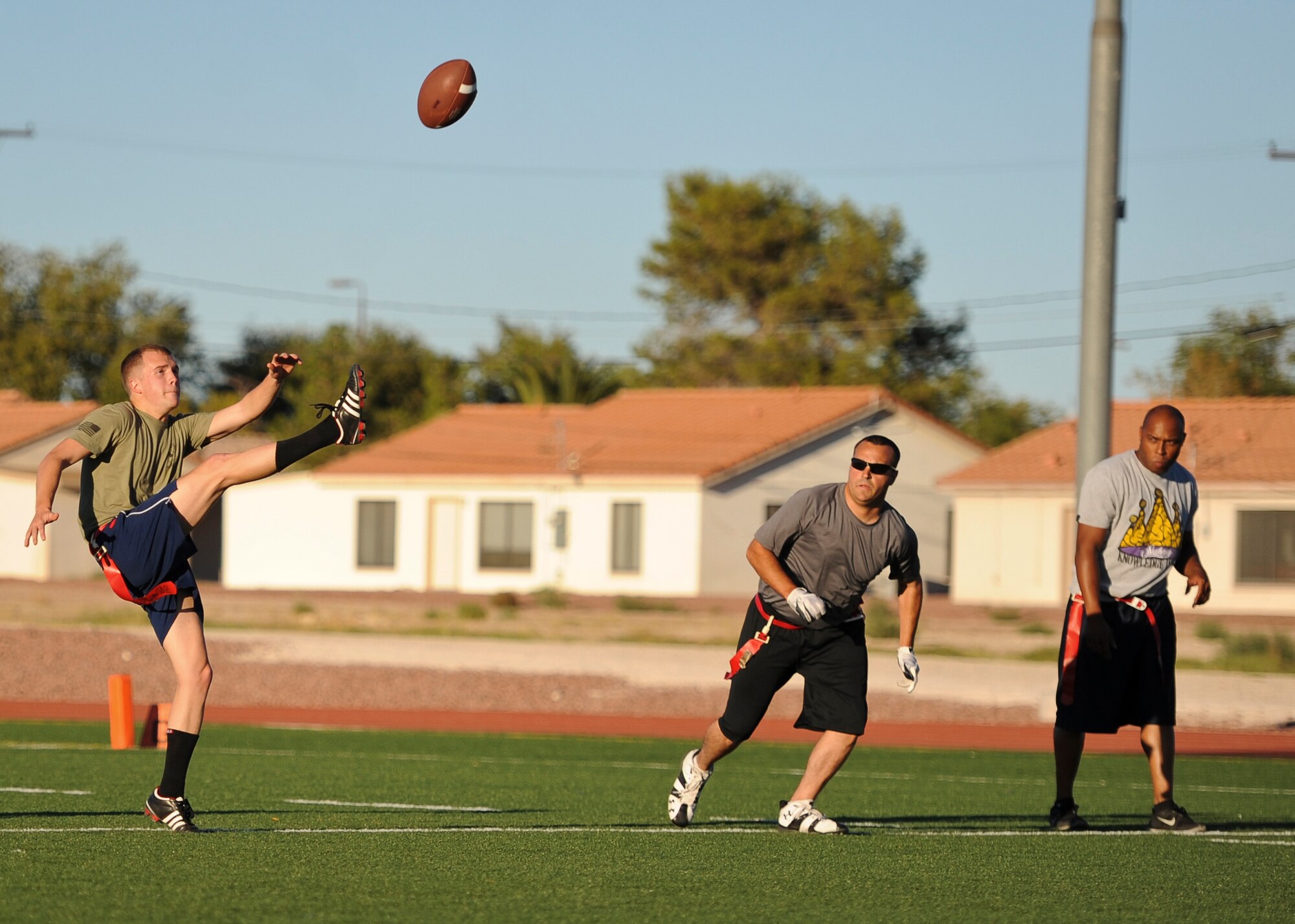 A member of the 757th Aircraft Maintenance Squadron’s Thunder team punts the ball during a game against the 757th AMXS’ Flanker team during a game at Nellis Air Force Base, Nev., Oct. 6, 2014. Flag football games are played Monday through Thursday on the football field behind the Warrior Fitness Center. (U.S. Air Force photo by Airman 1st Class Mikaley Towle)