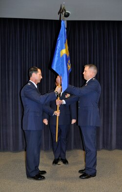 Col. Karl Stark (left), 152nd Airlift Wing Commander passes the flag to Lt. Col. Tony Machabee (right), the new 192nd Airlift Squadron Commander as he assumes responsibility as the newly appointed commander. (USAF Photo by Master Sgt. Paula Macomber, 152nd Airlift Wing Public Affairs/RELEASED.)