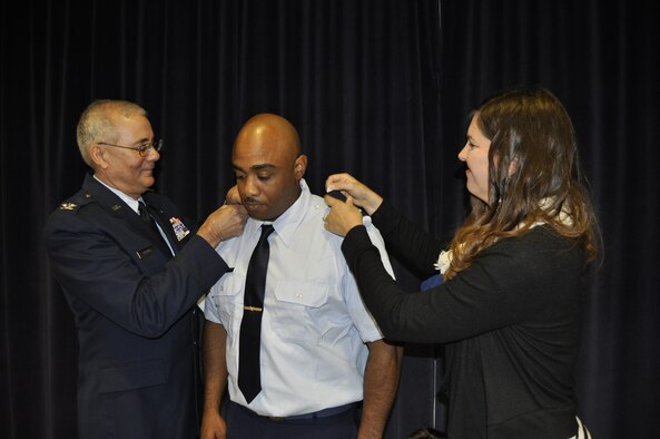 Ch. Tim Gregory (left) and Christena Gilliam (right) pins 1st Lt. Shay Gilliam’s insignia on during his commissioning ceremony at the Nevada Air National Guard Base on Oct. 1, 2014. Gilliam is the Nevada Air National Guard's first African-American Chaplain.