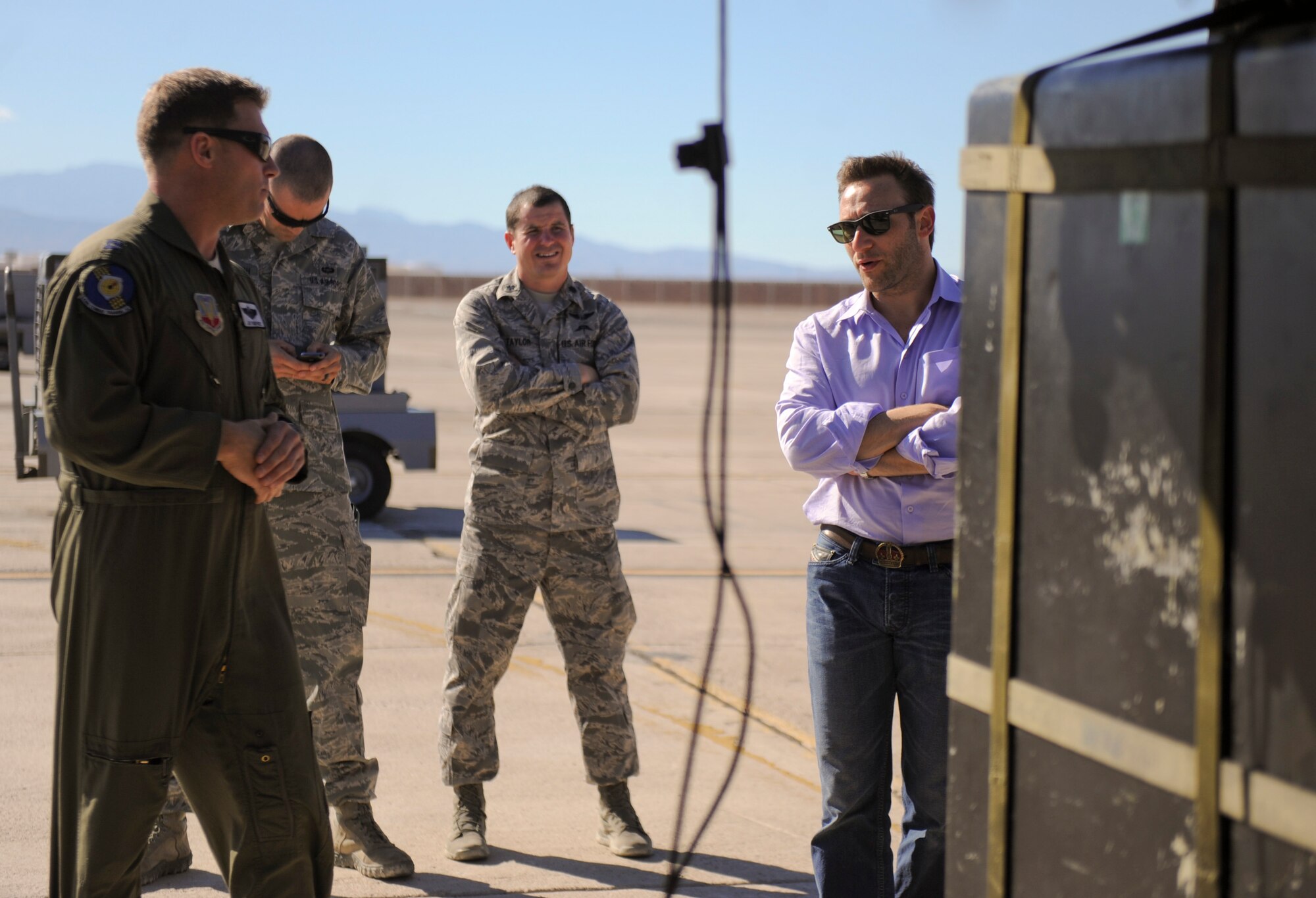 Simon Sinek, an internationally renowned speaker and author, is briefed by a member of the 66th Rescue Squadron during his visit to Nellis Air Force Base, Nev., Oct. 1, 2014. While visiting the 66th Rescue Squadron, Sinek was briefed about the capabilities and mission of the HH-60 Pave Hawk helicopter. (U.S. Air Force photo by Airman 1st Class Mikaley Towle)