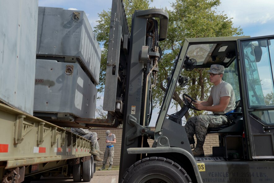 Airman 1st Class Ross Karrick, 22nd Logistic Readiness Squadron fuel distribution apprentice, loads a training bin Oct. 8, 2014, at McConnell Air Force Base, Kan. He learned how to operate a forklift to provide more capability for his unit. (U.S. Air Force photo/Airman 1st Class Colby L. Hardin)