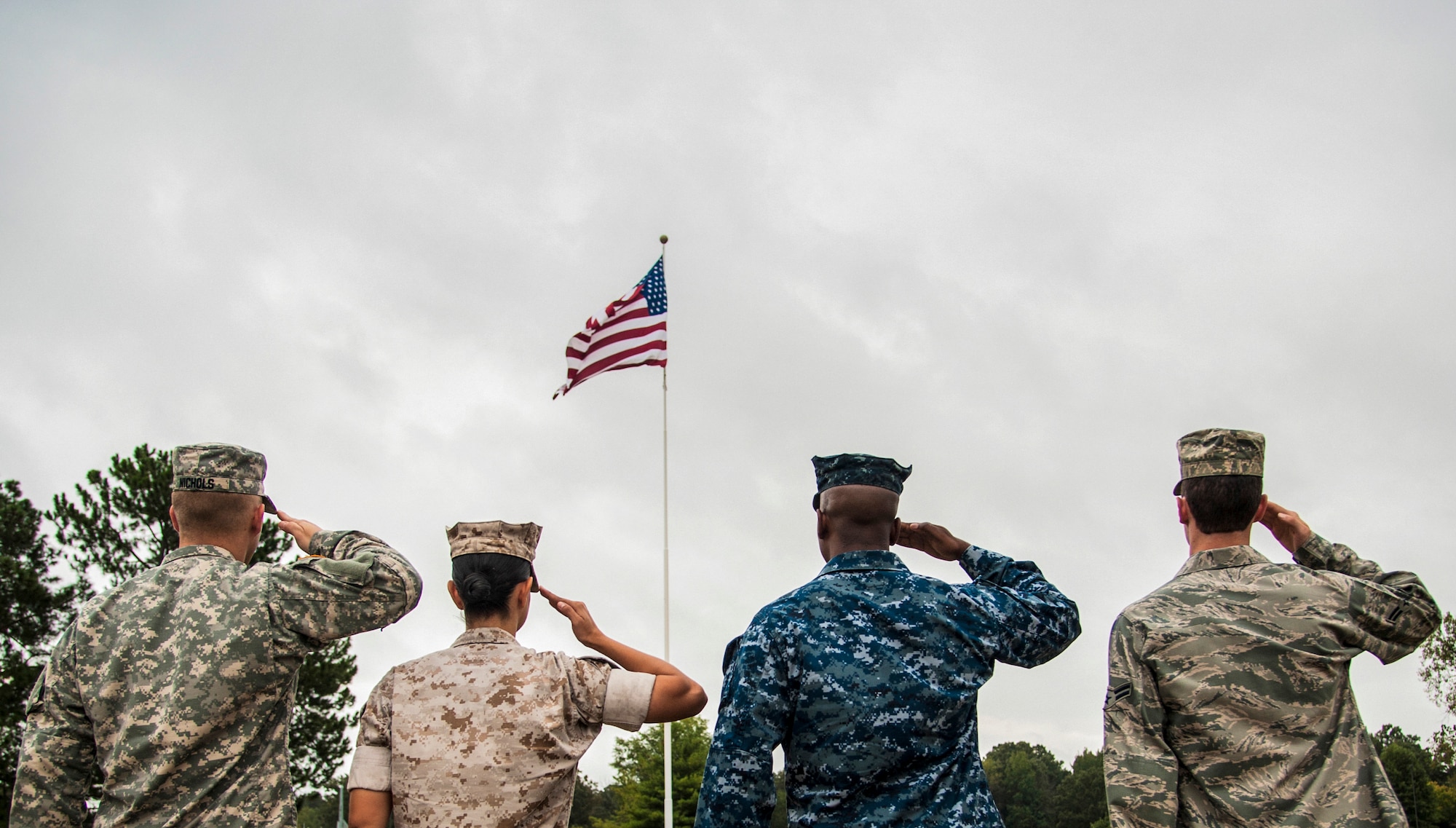 Service members salute the U.S. flag during a Retreat ceremony Oct. 2, 2014, at Little Rock Air Force Base, Ark. The four military members representing each branch of the U.S. military, assembled to show solidarity, in observance of the Retreat ceremony. (U.S. Air Force photo by Airman 1st Class Harry Brexel)
