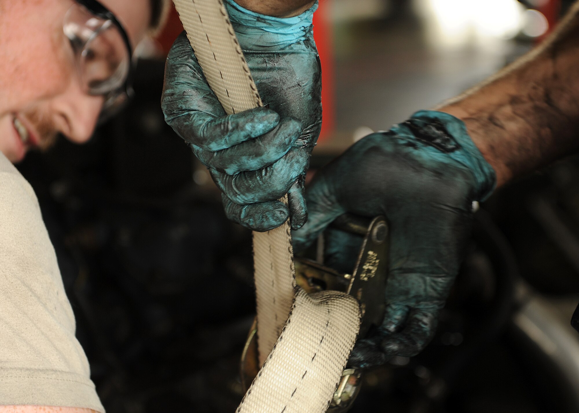 19th Logistics Readiness Squadron material handling equipment shop technicians, use a ratchet strap to support a hydraulic pump on a Halvorsen 25K aircraft cargo loader Sept. 16, 2014, at Little Rock Air Force Base, Ark. The technicians used the strap to lift the hydraulic pump to gain access in order to replace the belts. (U.S. Air Force photo by Airman 1st Class Scott Poe)