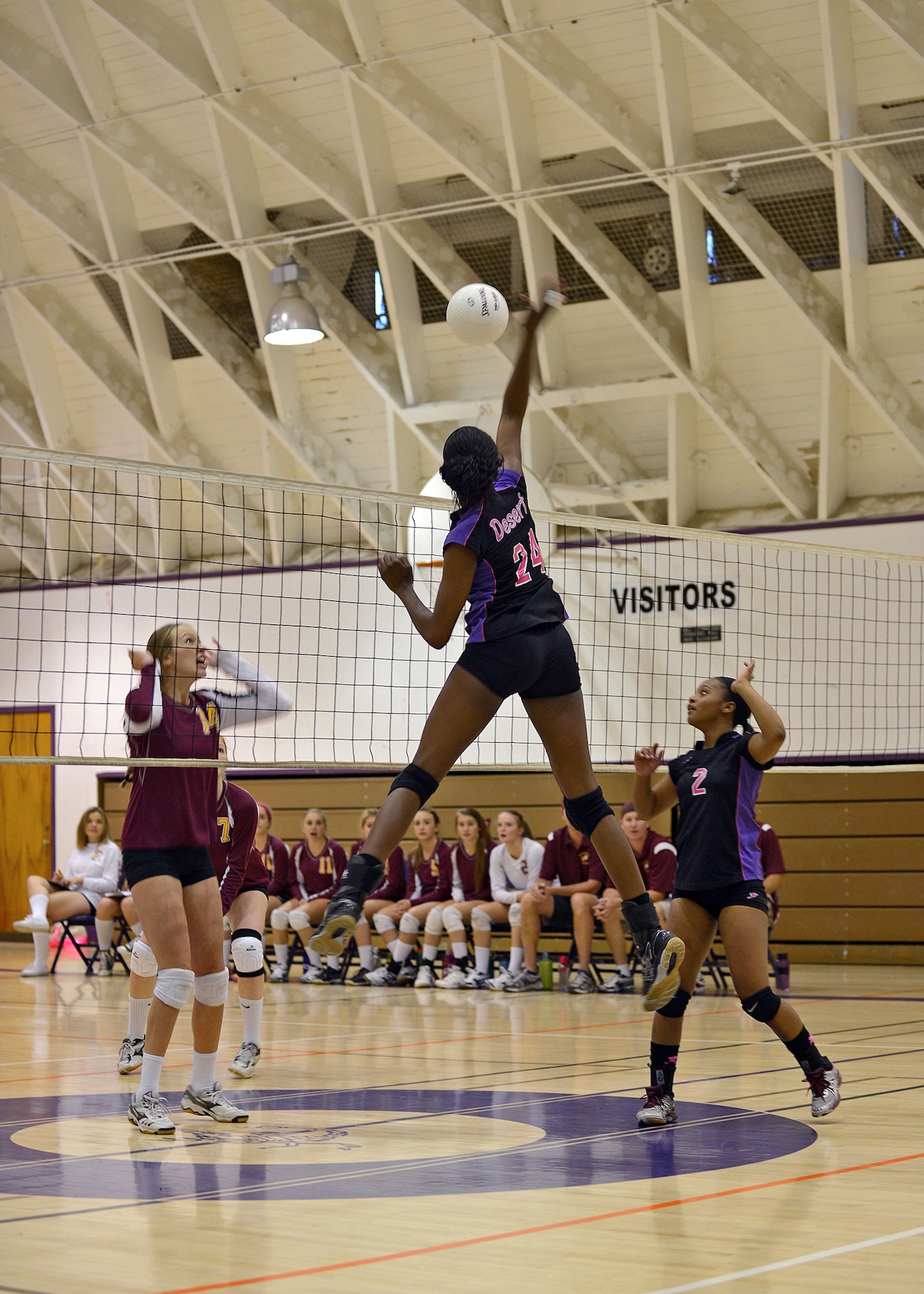 Tesheara Nelson, #2, Desert Junior Senior High School girls’ volleyball team captain, sets up Devyn Cross, #24, for the kill against a Mammoth High School blocker Oct. 3 at DJSHS. The Desert Scorpions volleyball team won Friday's home conference match against Mammoth by a score of 3-2. Last year, the DJSHS girls’ volleyball team finished their season as Desert Mountain League Tri-Champions along with Desert Christian and Mammoth High Schools. The team is currently 5-0 in the Desert Mountain League standings. (U.S. Air Force photo by Jet Fabara)