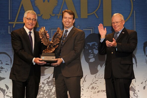 Secretary of Defense Chuck Hagel (left) presents the Secretary of Defense Employer Support Freedom Award to Washoe County School District Superintendent Pedro Martinez (center), while ESGR national chair, Paul E. Mock applauds.  DoD photo by U.S. Air Force Master Sgt. Adrian Cadiz.  


