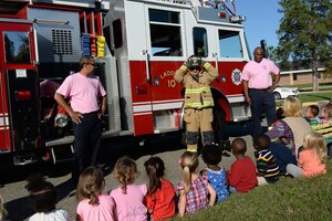 Firefighters from the Fort Eustis Fire and Emergency Service visit children at the Madison Child Development Center during Fire Prevention Week at Fort Eustis, Va., Oct. 8, 2014. Firefighters donned safety equipment to familiarize children with the appearance, to limit the possibility of fear, should a firefighter need to rescue them in the future. (U.S. Air Force photo by Staff Sgt. Teresa J. Cleveland/Released)