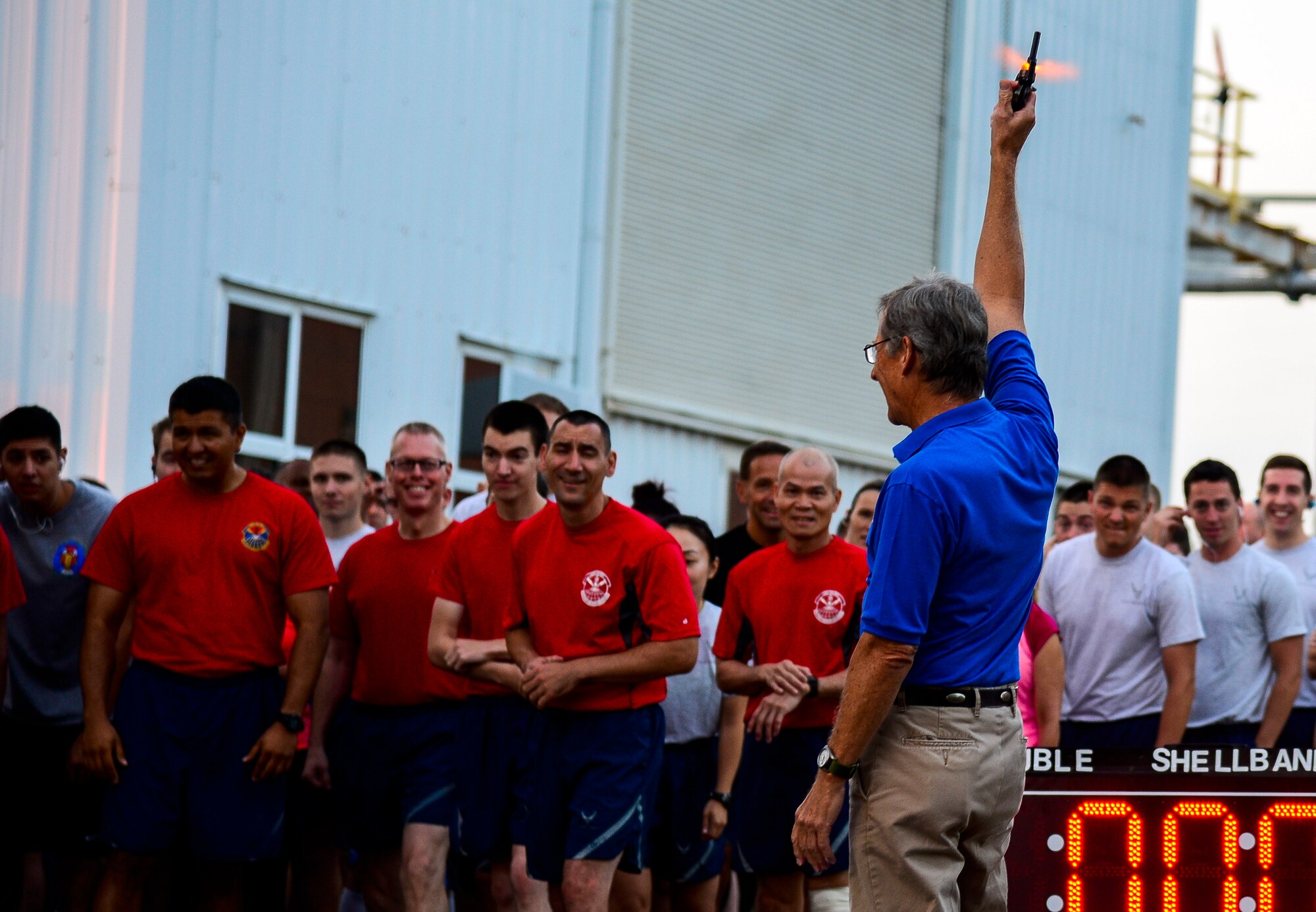 Mr. John Hickok, 633rd Force Support Squadron fitness center director, signals the start of a 5k during the Joint Base Langley-Eustis Warrior Olympics at Langley Air Force Base, Va., Oct. 3, 2014. The Olympics were held as a way to promote fitness and boost morale among units JBLE units. (U.S. Air Force photo by Senior Airman Kayla Newman/Released)