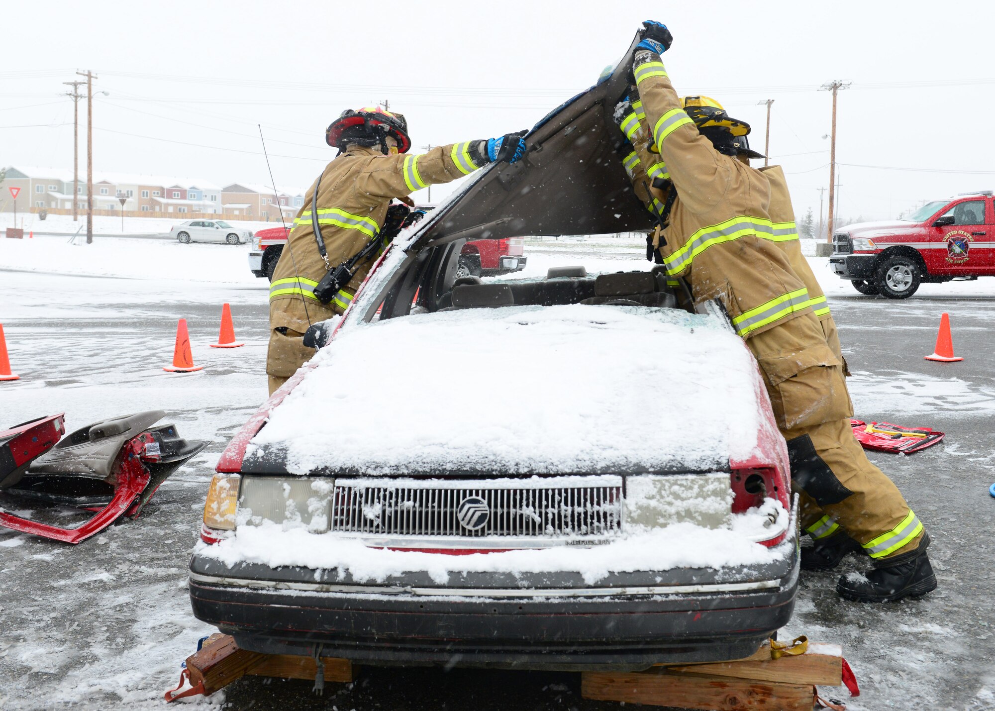 Icemen firefighters assigned to the 354th Civil Engineer Squadron perform the final stages of a vehicle extrication demonstration during the Eielson Fire Department open house Oct. 5, 2014, Eielson Air Force Base, Alaska. Depending on the severity of the crash, firefighters will use many tools to get victims removed from the site and ensure their safety. (U.S. Air Force photo by Senior Airman Ashley Nicole Taylor/Released)