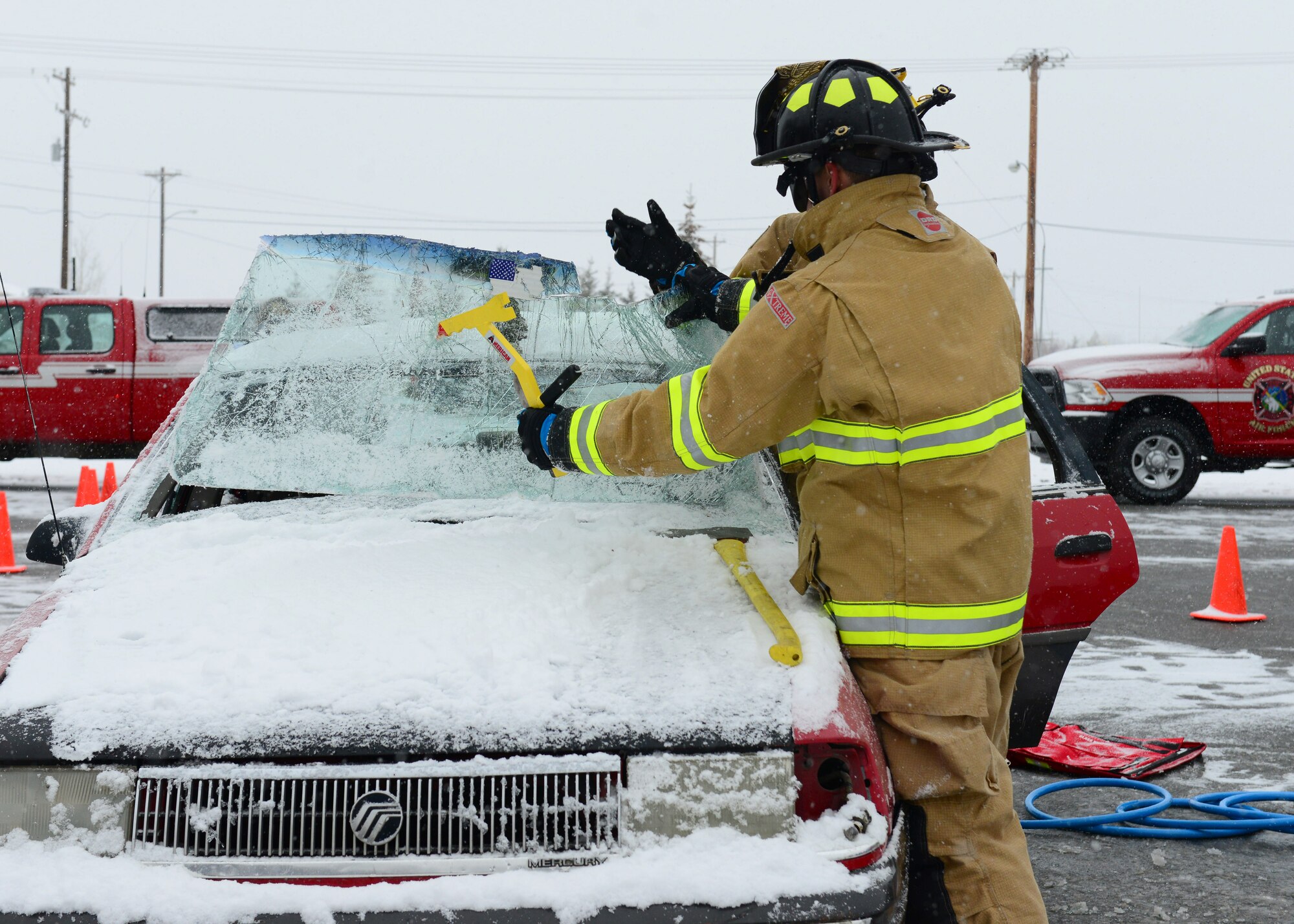 Firefighters assigned to the 354th Civil Engineer Squadron use a window saw to remove a windshield during a vehicle extrication demonstration Oct. 5, 2014, Eielson Air Force Base, Alaska. The window saw is used to cut the front window of a vehicle which will allow the firefighters to gain access to a crash victim. (U.S. Air Force photo by Senior Airman Ashley Nicole Taylor/Released)