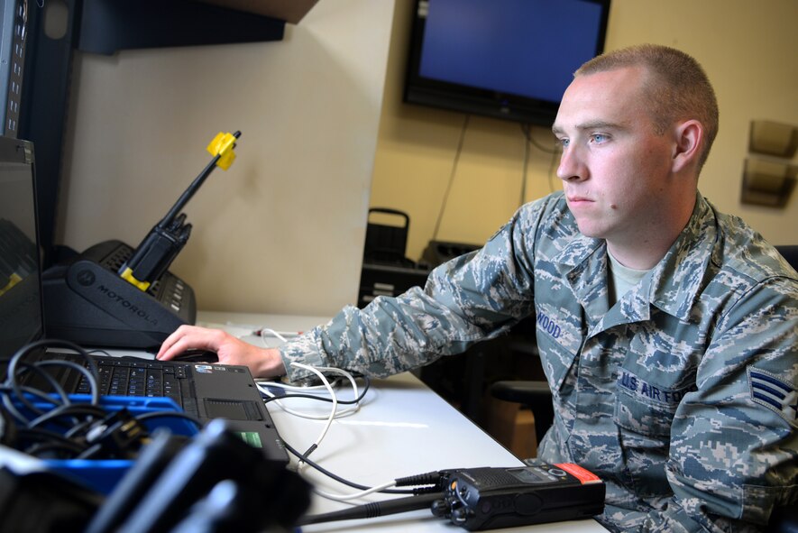 U.S. Air Force Senior Airman Steven Wood, 20th Communications Squadron client systems technician, uses his computer to program a land mobile radio at Shaw Air Force Base, S.C., Oct. 8, 2014. LMRs are used by many different squadrons to communicate across base with ease. (U.S. Air Force photo by Airman 1st Class Jonathan Bass/Released)