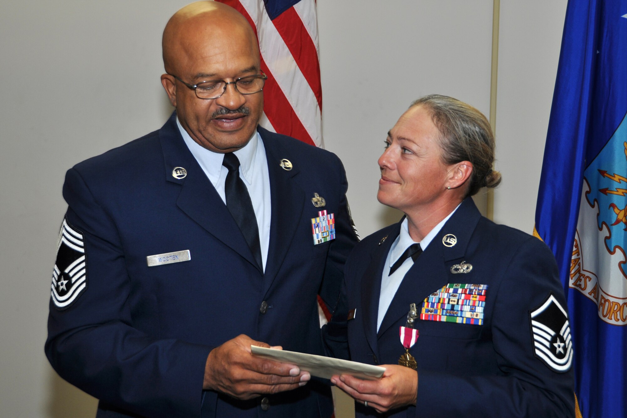 U.S. Air Force Master Sgt. Jessica Wiley, 307th RED HORSE Squadron, accepts a presentation from Chief Master Sgt. Timothy Wooten during Wiley's retirement ceremony Oct. 4, 2014, at Barksdale Air Force Base, La.  Wiley is retiring after 21 years of service. (U.S. Air Force photo by Master Sgt. Mary Hinson/Released)