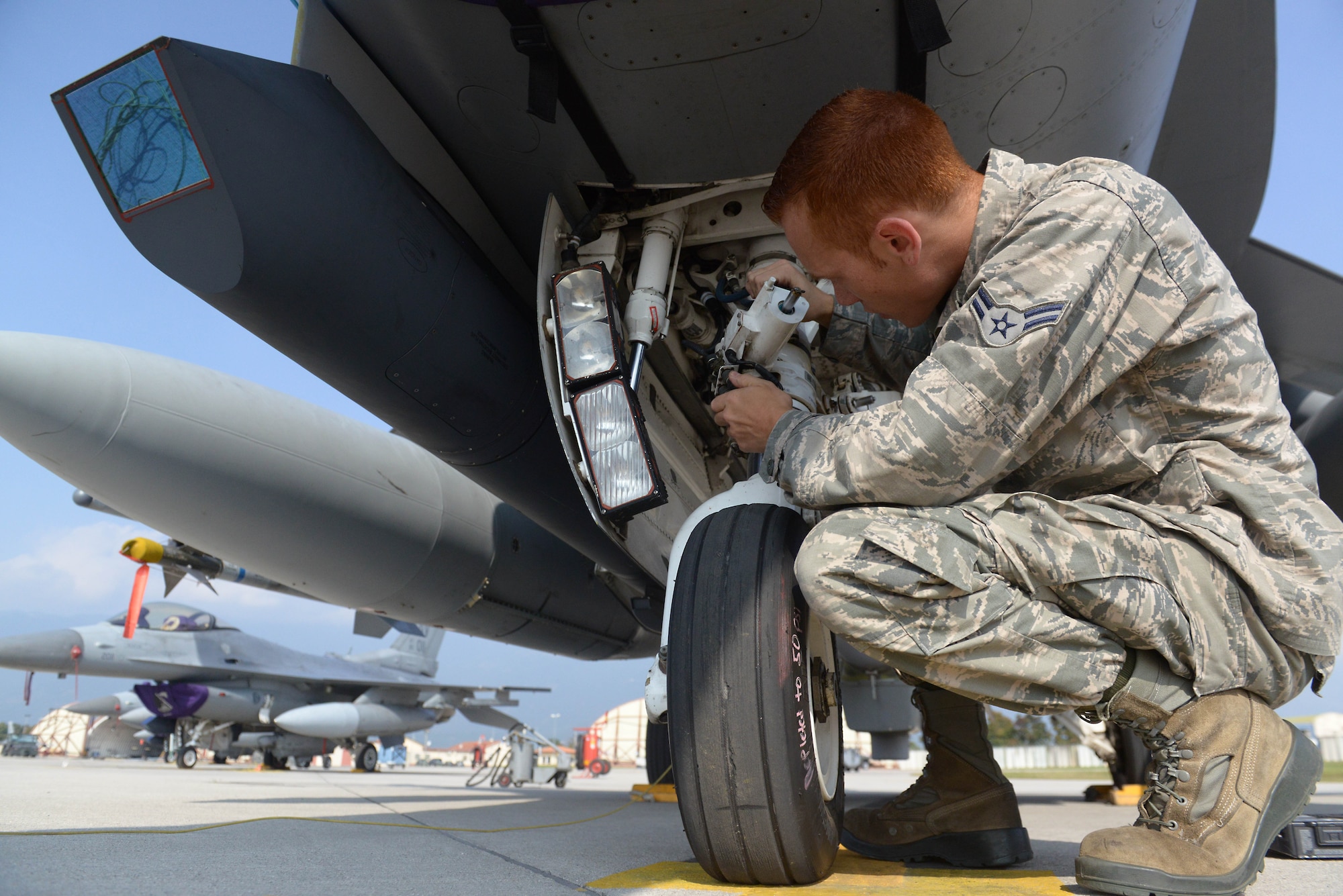 Airman 1st Class Matthew Galati, 31st Aircraft Maintenance Squadron crew chief, checks the landing gear of an F-16 Fighting Falcon during pre-flight inspections, Oct. 7, 2014, at Aviano Air Base, Italy. Crew chiefs meticulously inspect a jet for any mechanical problems before a pilot takes flight. (U.S. Air Force photo/Airman 1st Class Ryan Conroy) 