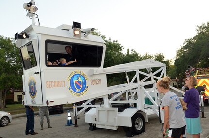 Joint Base San Antonio-Randolph Family Housing residents take a ride aboard Randolph's Skywatch Flyer mobile surveillance tower during "National Night Out" Oct. 7, 2014, at JBSA-Randolph. NNO is a nationwide effort to heighten crime prevention awareness, generate support for local anti-crime programs and strengthen neighborhood spirit and police-community partnerships for a safer nation. (U.S. Air Force photo by Johnny Saldivar)