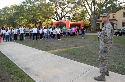 Col. Michael Gimbrone, 502nd Security Forces and Logistics Support Group commander, addresses the crowd during "National Night Out" Oct. 7, 2014, at Joint Base San Antonio-Randolph. NNO is a nationwide effort to heighten crime prevention awareness, generate support for local anti-crime programs and strengthen neighborhood spirit and police-community partnerships for a safer nation. (U.S. Air Force photo by Johnny Saldivar)