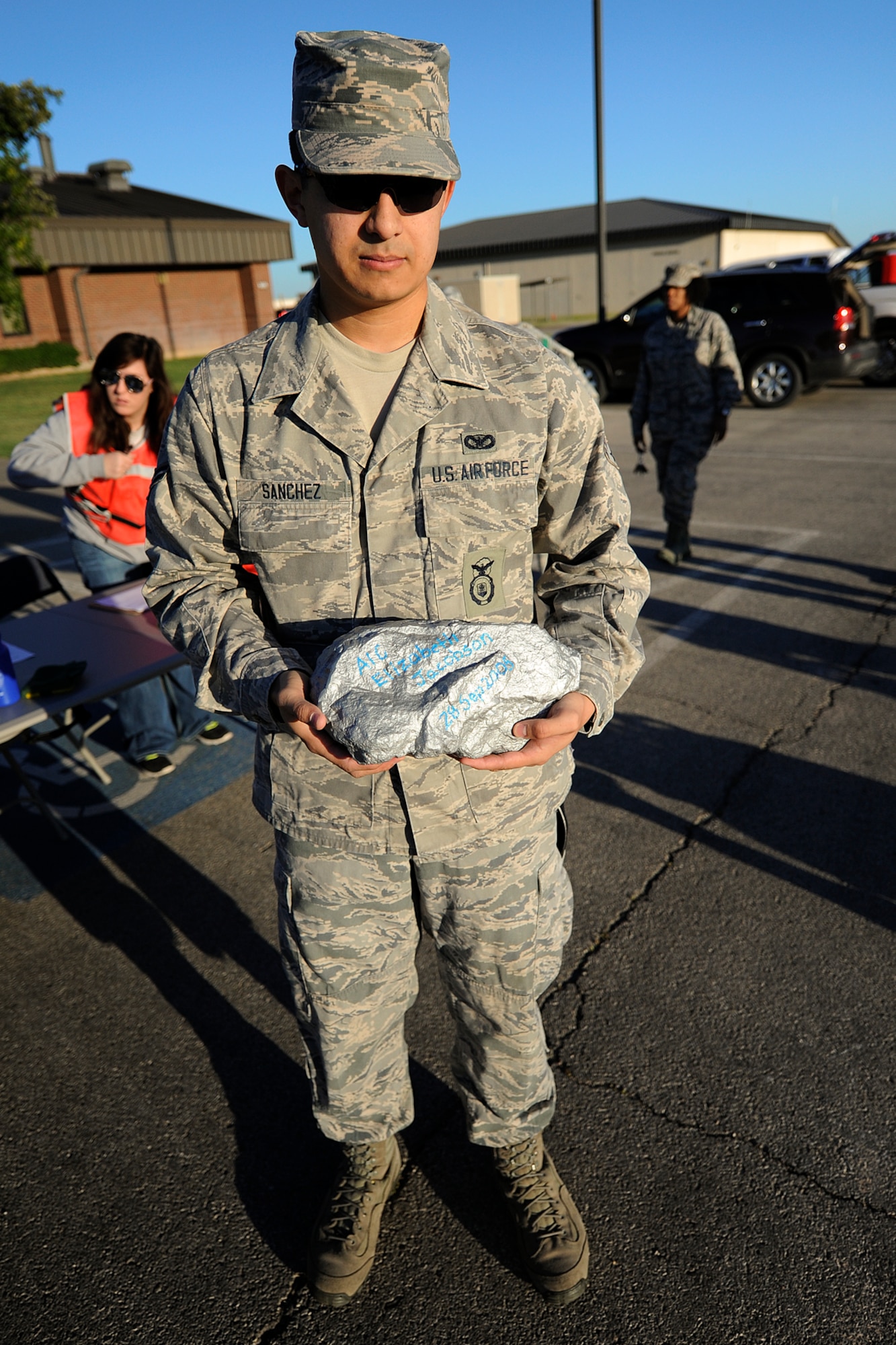 GOODFELLOW AIR FORCE BASE, Texas – Airman 1st Class Eduardo J. Sanchez, 17th Security Forces Squadron entry controller and ruck march participant, holds the Airman 1st Class Elizabeth Jacobson Rock during the 8th Annual Airman 1st Class Jacobson 4.1-Mile Memorial Ruck March at the 17th SFS parking lot Oct. 4. The rock weighs exactly 21 pounds symbolizing Jacobson’s age at her death. The individual who carries the rock in his/her ruck during the march gets to sign it. (Air Force photo/ Airman 1st Class Devin Boyer)