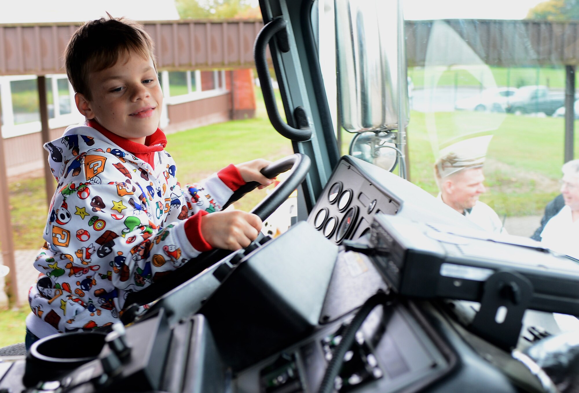 Landon Pace, son of U.S. Air Force Staff Sgt. Amy Dietrich, 52nd Logistics Readiness Squadron individual equipment element NCO in charge, gets behind the wheel of a fire truck during a visit from 52nd Civil Engineer Squadron firefighters at SES at Spangdahlem Air Base, Germany, Oct. 8, 2014. Students learned about the different equipment firefighters bring with them when they get an emergency call. (U.S. Air Force photo by Airman 1st Class Luke J. Kitterman/Released)