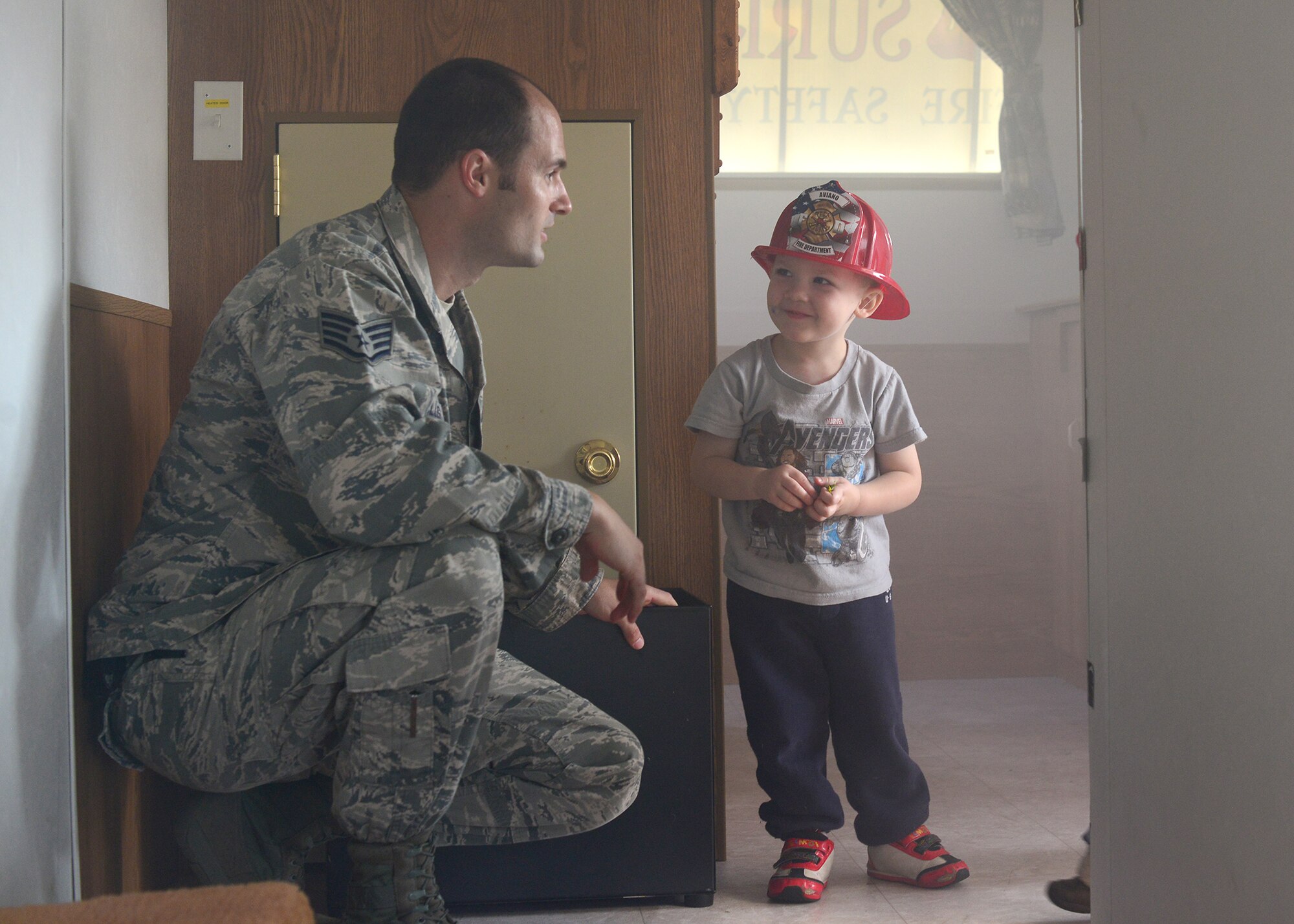 Staff Sgt. Kyle Rollins, 31st Civil Engineer Squadron firefighter, shows a child how to exit a smoke-filled room during a school visit, Oct. 6, 2014, at Aviano Air Base, Italy. Following this year’s theme, "Smoke Alarms Save Lives: Test Yours Every Month!,” Aviano’s firefighters educated the base population on the importance of maintaining their smoke alarms and testing them regularly. (U.S. Air Force photo/Senior Airman Michael Battles)