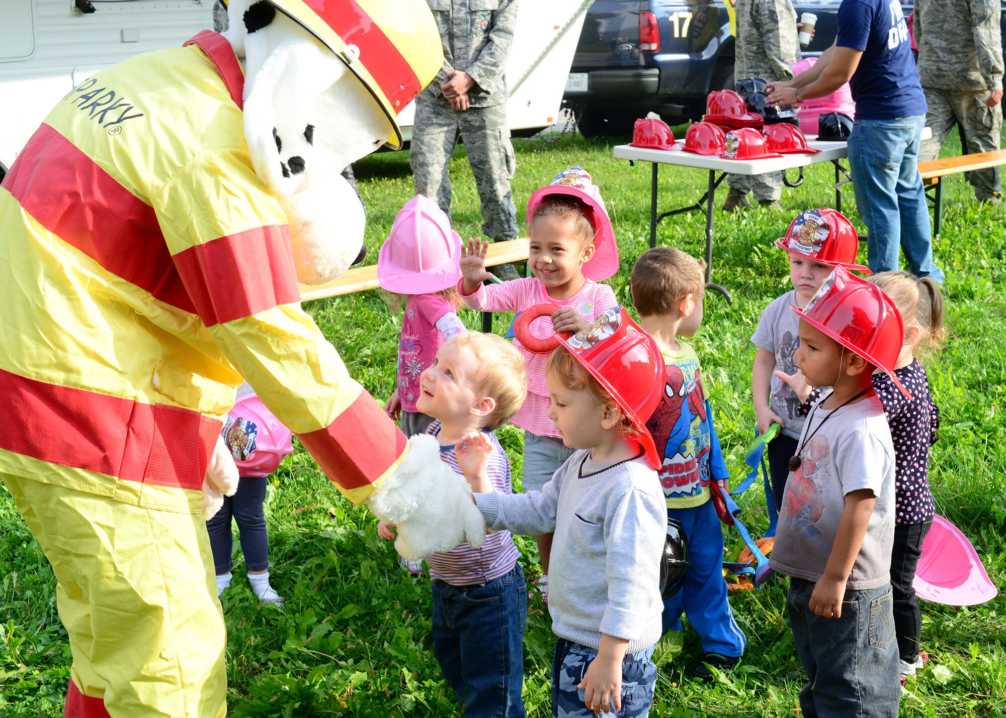 Sparky, the fire dog, greets children during a fire prevention week child development center visit, Oct. 6, 2014, at Aviano Air Base, Italy. In addition to an open house and child development center visit, the Fire Department hosted a library reading and a fire safety demonstration for the elementary school. (U.S. Air Force photo/Senior Airman Michael Battles)