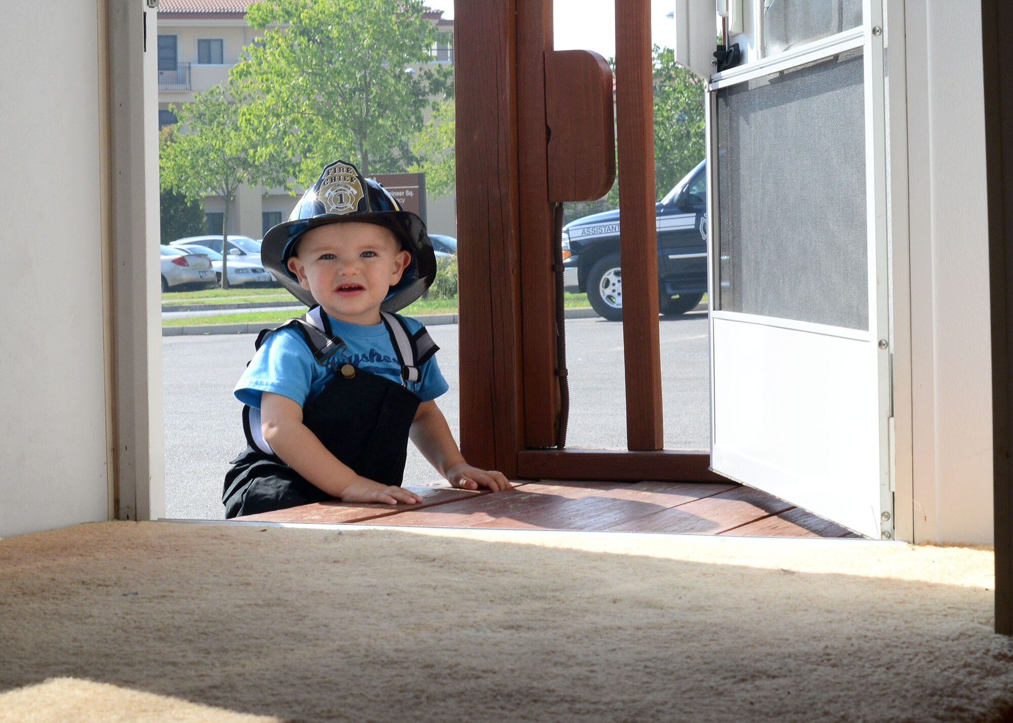 Logan, age 20 months, peers into the doorway of the Aviano Fire Department’s simulated burning house during a fire department open house, Oct. 5, 2014, at Aviano Air Base, Italy. National Fire prevention Week was established to commemorate the Great Chicago Fire of 1871, which killed 300 people, left 100,000 homeless, destroyed 17,400 structures and burned 2,000 acres. (U.S. Air Force photo/Senior Airman Michael Battles)