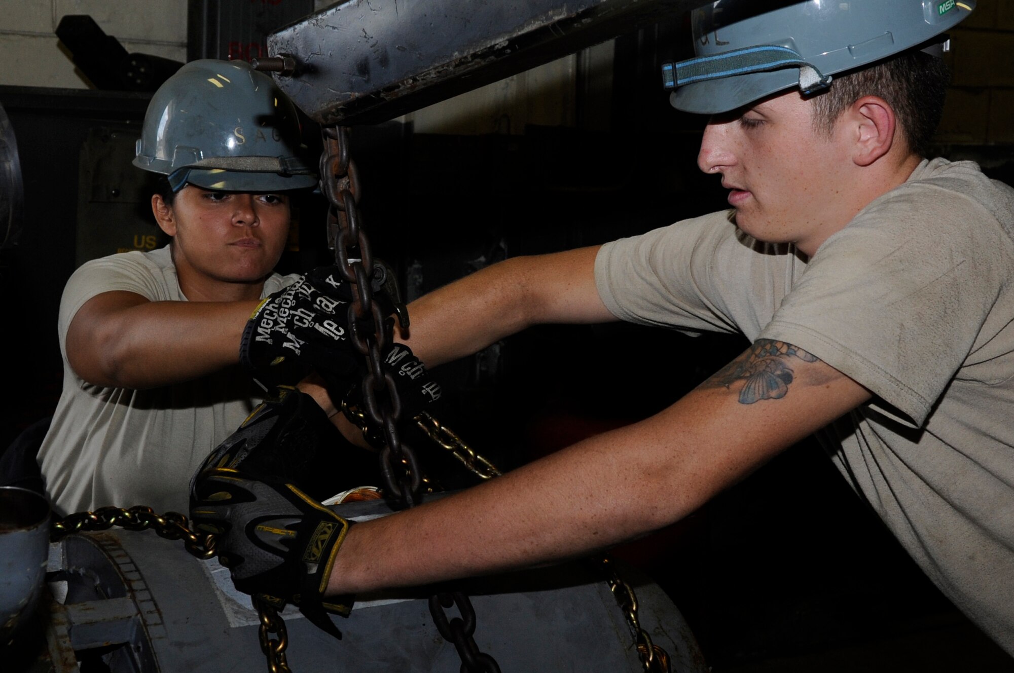U.S. Air Force Airmen 1st Class Spencer Ueckert, left, and Jordan Wolverton, both 18th Equipment Maintenance Squadron aircraft ground equipment technicians, secure and engine with chains to be taken away for depot-level maintenance while on Kadena Air Base, Japan, Oct. 6, 2014. AGE technicians are responsible for the distribution and maintenance of more than 1,100 pieces of equipment base-wide. (U.S. Air Force photo by Senior Airman Marcus Morris/Released)