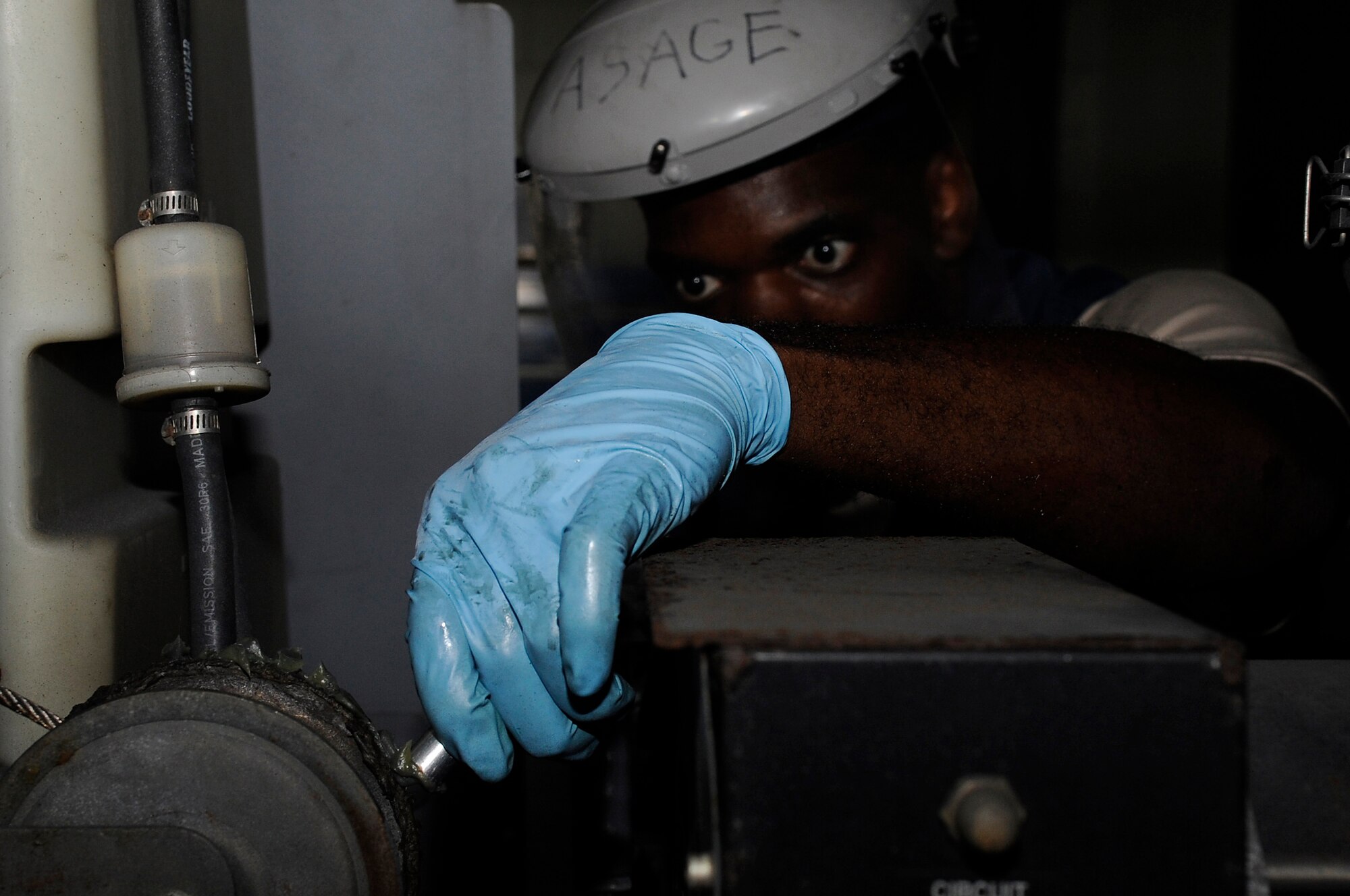 U.S. Air Force Senior Airman Vaughn Page, 18th Equipment Maintenance Squadron aircraft ground equipment technician, applies lubricant to chain in a portable light stand on Kadena Air Base, Japan, Oct. 6, 2014. AGE's mission is geared toward supporting all maintenance that's performed on aircraft. (U.S. Air Force photo by Senior Airman Marcus Morris/Released)