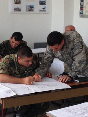 Staff Sgt. Luis Devotto, 435th Air Ground Operations Wing’s Contingency Readiness Group Air Advisor Branch air advisor special vehicle maintenance, goes over schematic of a Halvorsen Loader aircraft loader with a Bulgarian Joint Forces Command members in Plovdiv, Bulgaria. Devotto and Staff Sgt. Jonathan Rasmussen, 48th Logistics Readiness Squadron transportation specialist from Royal Air Force Lakenheath, England, trained 16 members for two Bulgarian movement control teams on the operations and maintenance of a Halvorsen aircraft loader. (Courtesy photo)