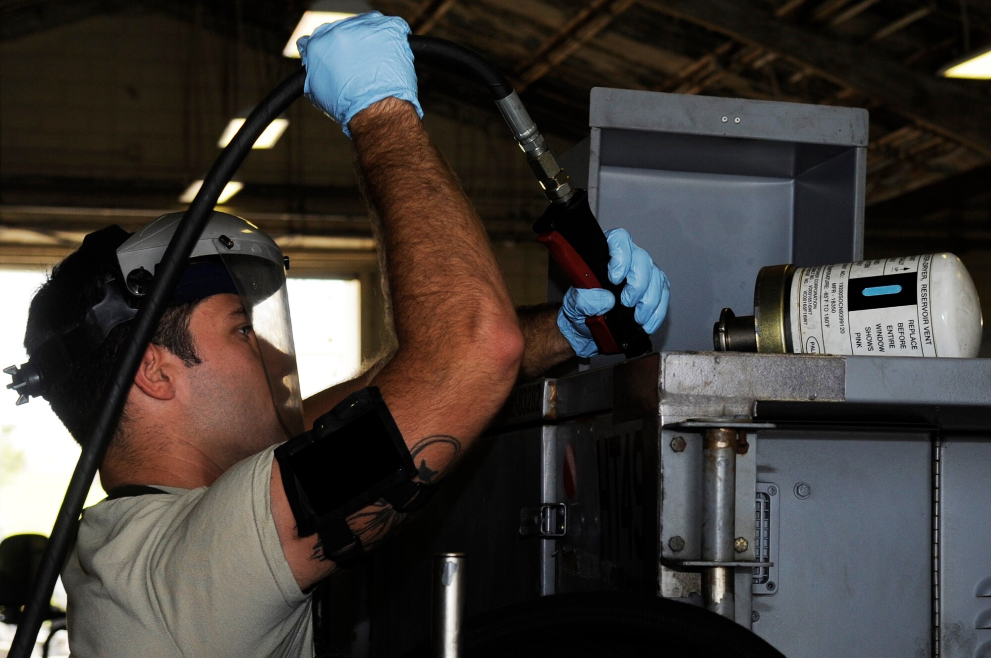U.S. Air Force Airman 1st Class Jacky Quillen, 18th Equipment Maintenance Squadron aircraft ground equipment technician, fills an aircraft portable hydraulic cart with hydraulic fluid on Kadena Air Base, Japan, Oct. 6, 2014. AGE technicians work on a wide range of equipment including flood lights, bomb lifts and hydraulic test stands. (U.S. Air Force photo by Senior Airman Marcus Morris/Released)