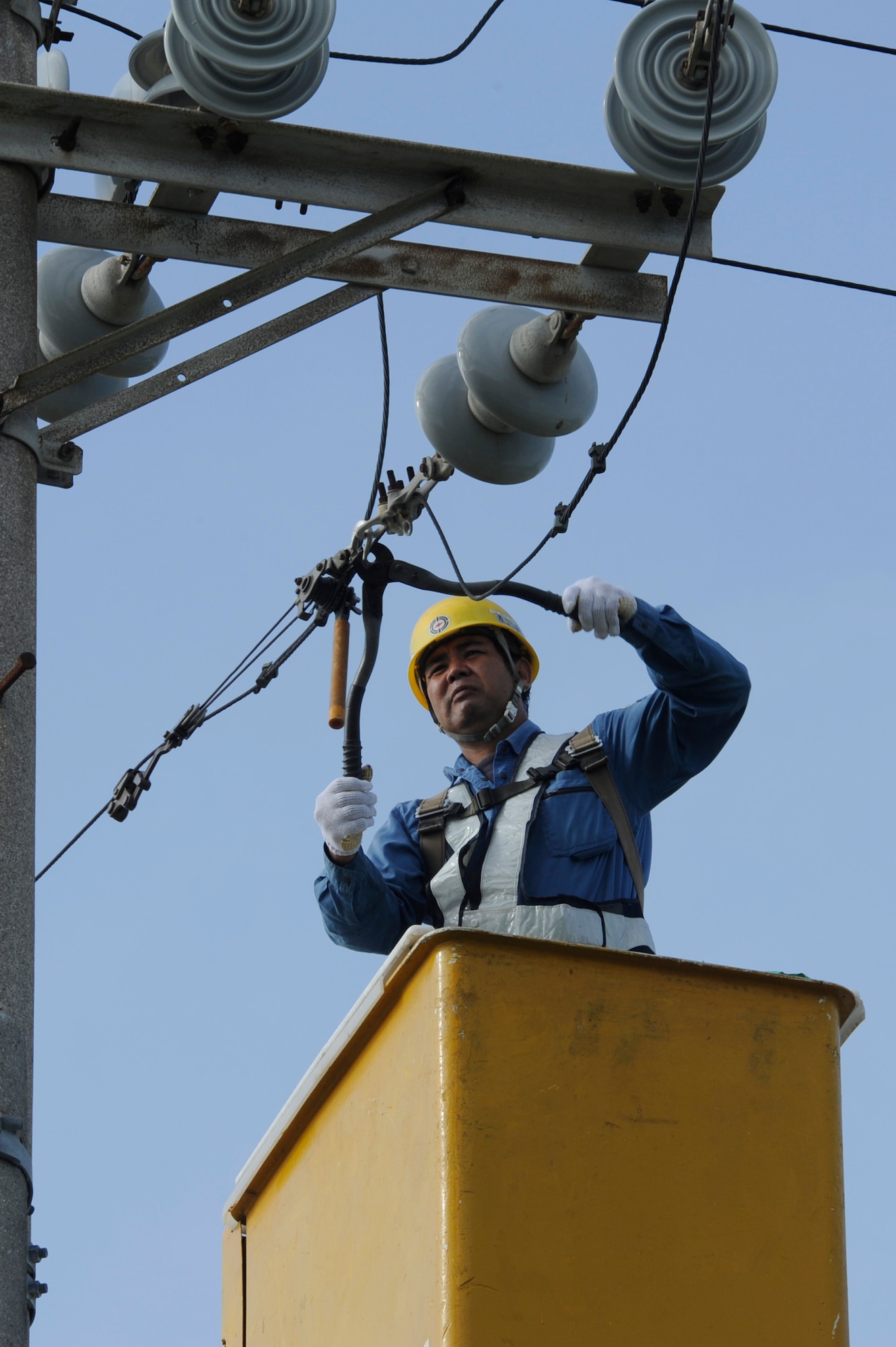 A contractor for the 718th Civil Engineer Squadron cuts down an overhead power line on Kadena Air Base, Japan, Oct. 6, 2014. The work was part of a project to replace Kadena’s overhead power lines with underground lines. (U.S. Air Force photo by Senior Airman Marcus Morris/Released)