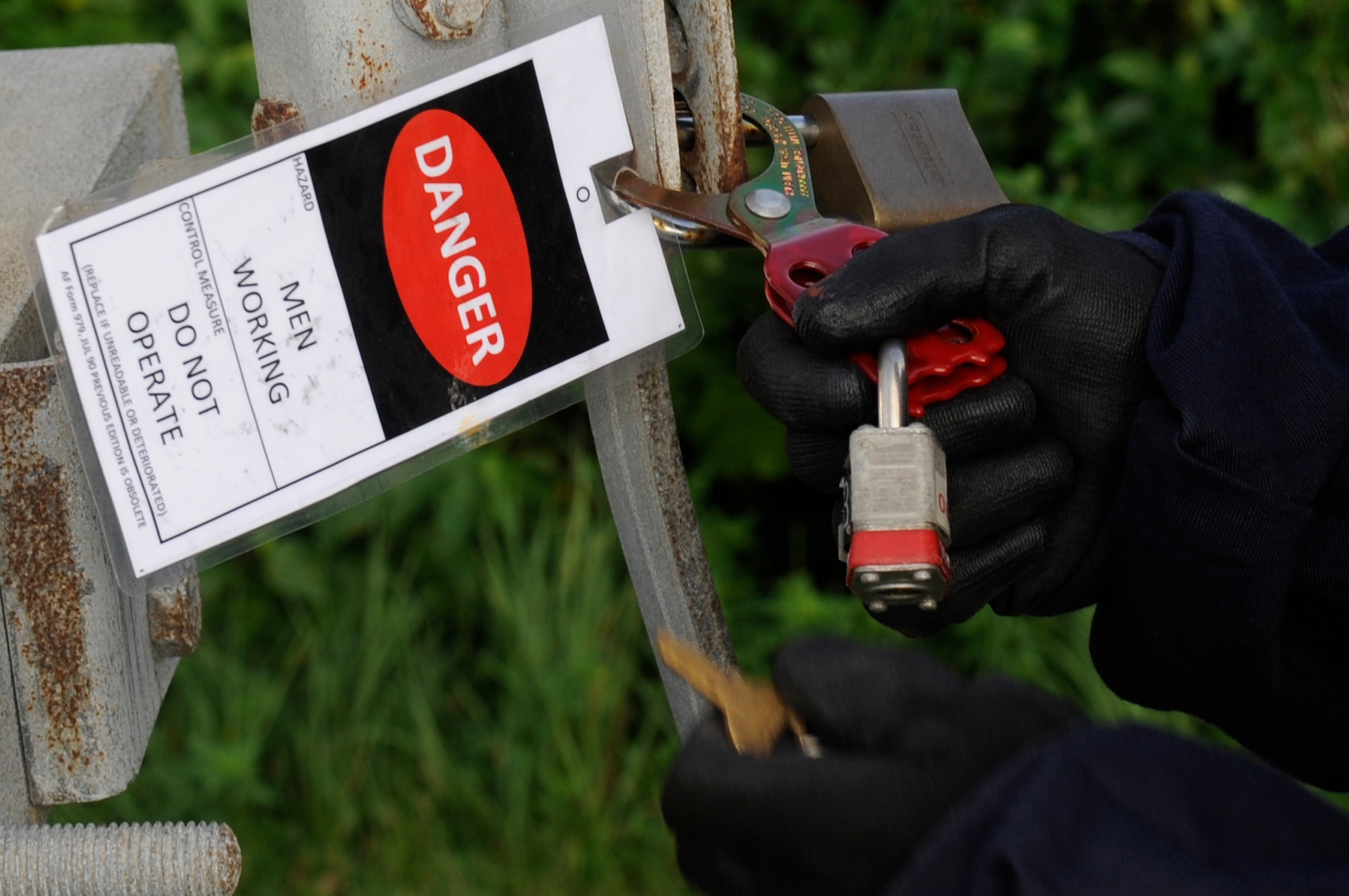 An electrician from the 18th Civil Engineer Squadron locks an overhead power line to ensure the power has been diverted from where lines will be cut down on Kadena Air Base, Japan, Oct. 6, 2014. The work was part of a project to replace Kadena’s overhead power lines with underground lines to mitigate potential environmental damage. (U.S. Air Force photo by Senior Airman Marcus Morris/Released)