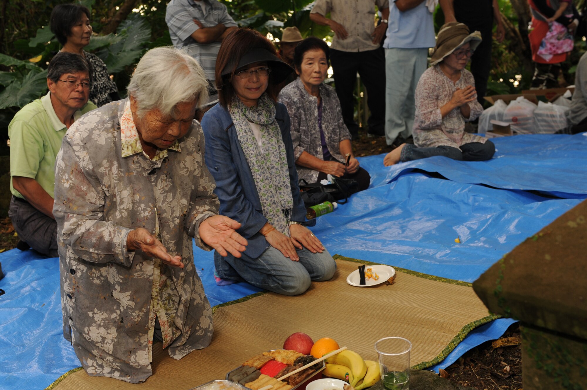 Shizuko Yara, an Okinawa City resident, says a prayer during Kikushu on Kadena Air Base, Japan, Oct. 2, 2014. Kikushu is a Japanese tradition in which community members gather in a common space to offer food to their ancestors and pray for the prosperity of their families and a successful harvest. A picnic is traditionally held afterward so community members can share a meal with the spirits of their ancestors. (U.S. Air Force photo by Airman 1st Class Zade C. Vadnais/Released)