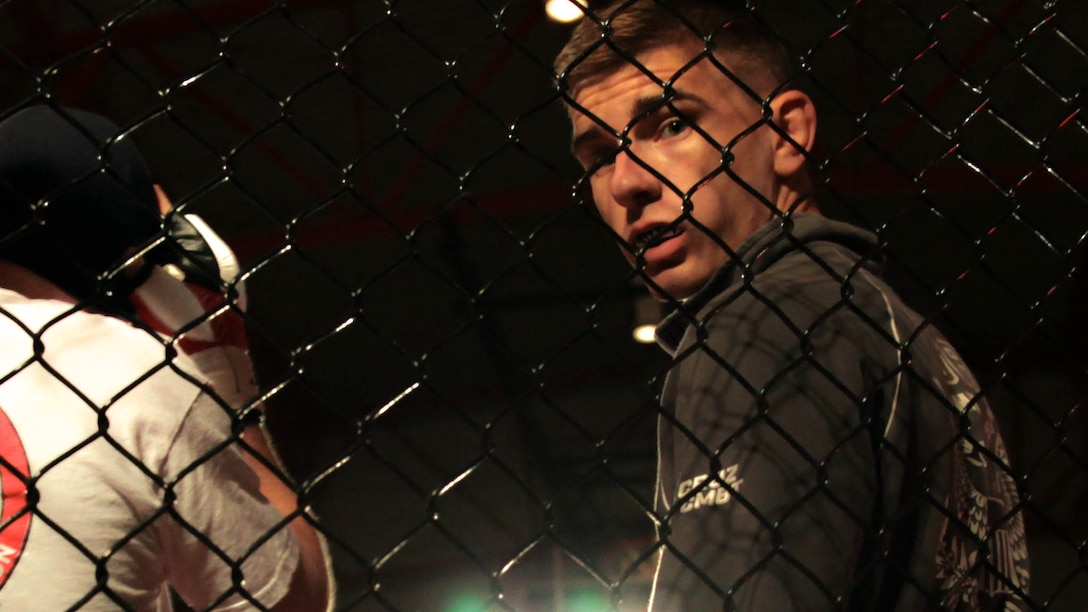 New Orleans - John Zimmer, a security specialist at Headquarters Battalion, Marine Forces Reserve, stands in the octagon minutes before his fight at the Caged Warrior Championship V on Oct. 4th, 2014, in Patterson, La. This was Zimmer’s first time competing in a mixed martial arts fight. 
