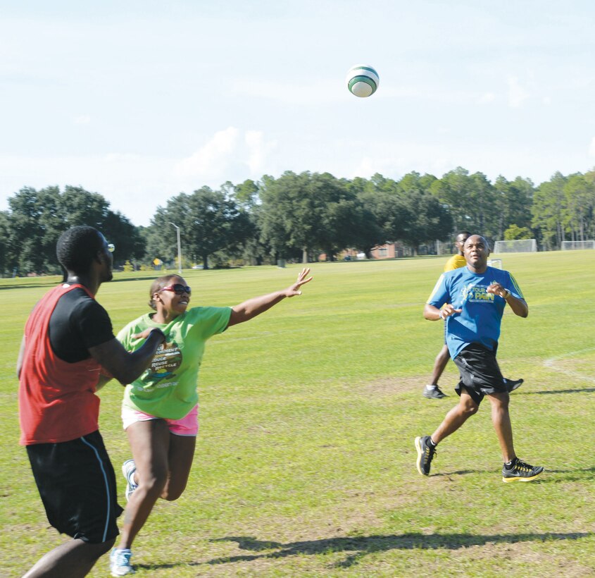 Petty Officer 1st Class Kewauna Stalls (center) attempts to deflect a pass, from an opposing team member, to Lt. Cmdr. Donald Mitchell during a handball game against fellow shipmates at Marine Corps Logistics Base Albany's Boyett Park, recently. 