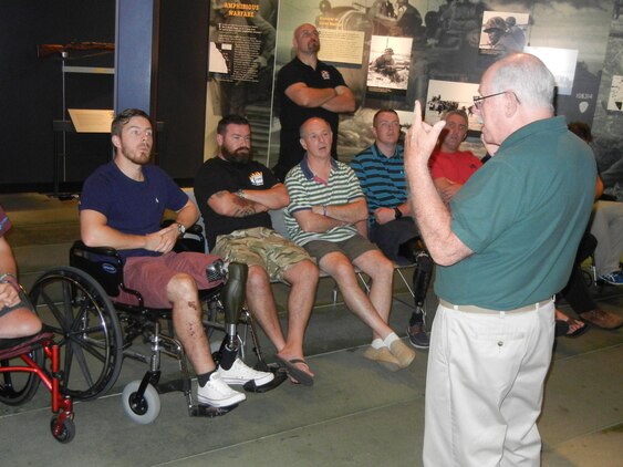 Docent Roger McIntosh speaks with British Wounded Warriors visiting the National Museum of the Marine Corps on Oct. 2.