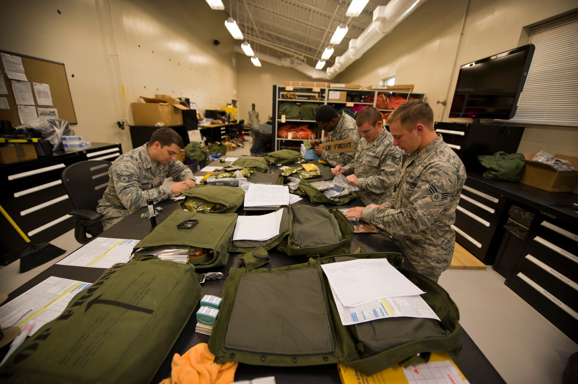 Aircrew flight equipment Airmen prepare survival kits at the 1st Special Operations Group Detachment 1 building on Hurlburt Field, Fla., Oct. 7, 2014. The kits include equipment in the event of an emergency egress. (U.S. Air Force photo/Senior Airman Krystal M. Garrett)