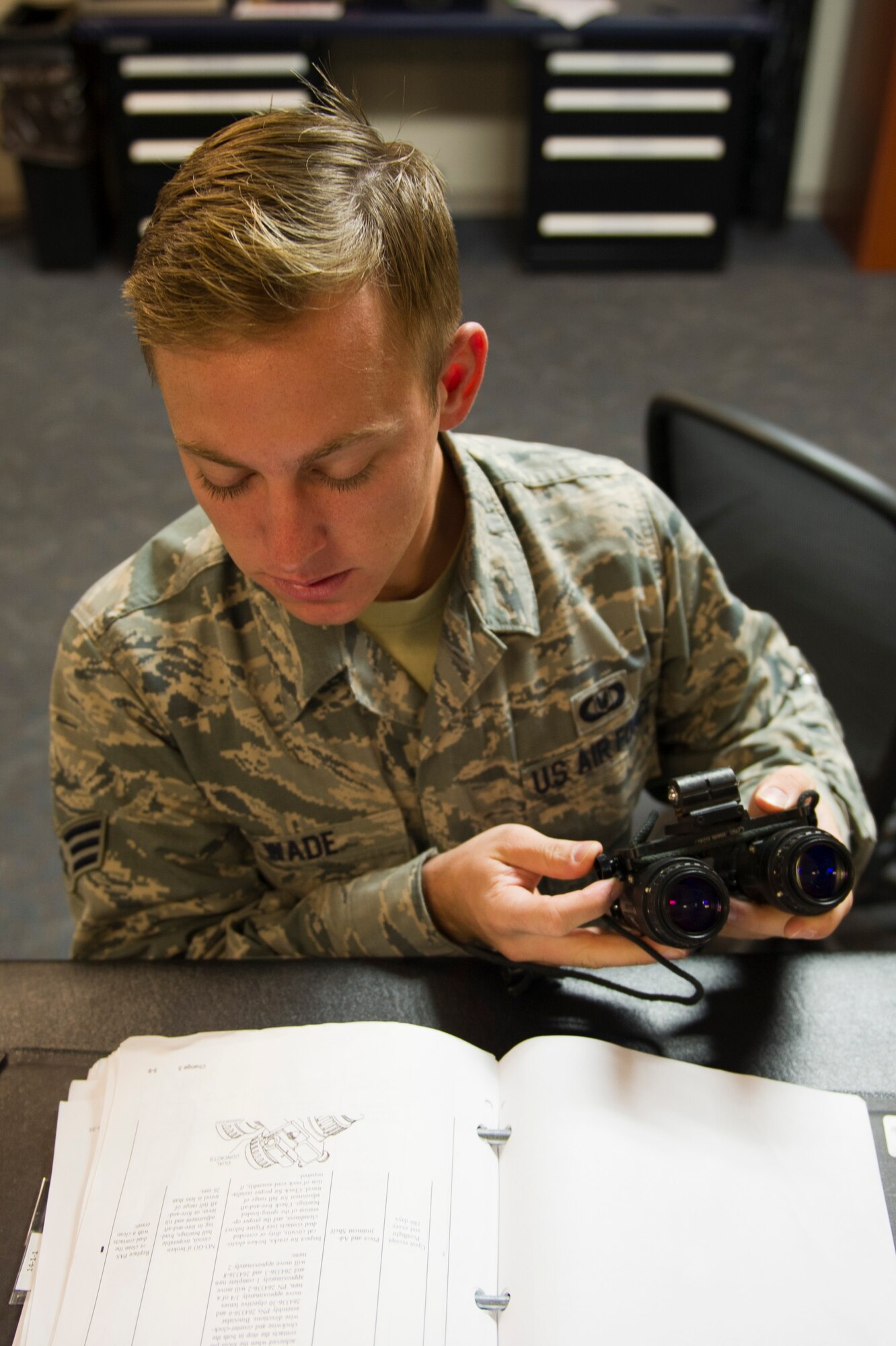 Senior Airman Jacob Wade, 34th Special Operations Squadron aircrew flight equipment journeyman, looks at a technical order to ensure he performs proper maintenance on night vision goggles at the 1st Special Operations Group Detachment 1 building on Hurlburt Field, Fla., Oct. 7, 2014. (U.S. Air Force photo/Senior Airman Krystal M. Garrett) 