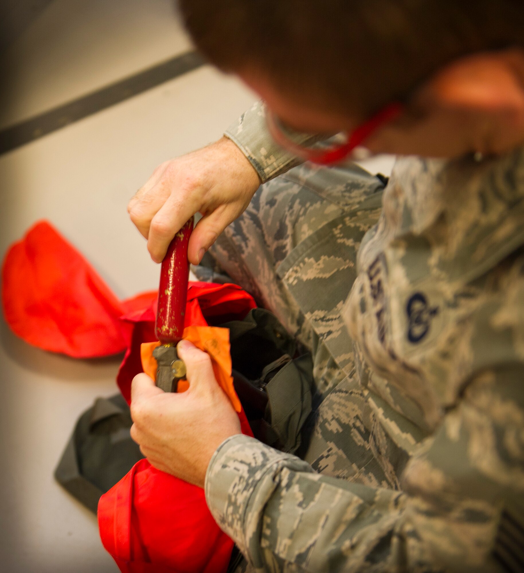 Staff Sgt. Daryl Heberling, 319th Special Operations Squadron aircrew flight equipment craftsman, attaches a carbon dioxide bottle to a Life Preserver Unit at the 1st Special Operations Group Detachment 1 building on Hurlburt Field, Fla., Oct. 7, 2014. After inflating, a six-hour leak test will be performed to ensure there are no problems with the LPU. (U.S. Air Force photo/Senior Airman Krystal M. Garrett)