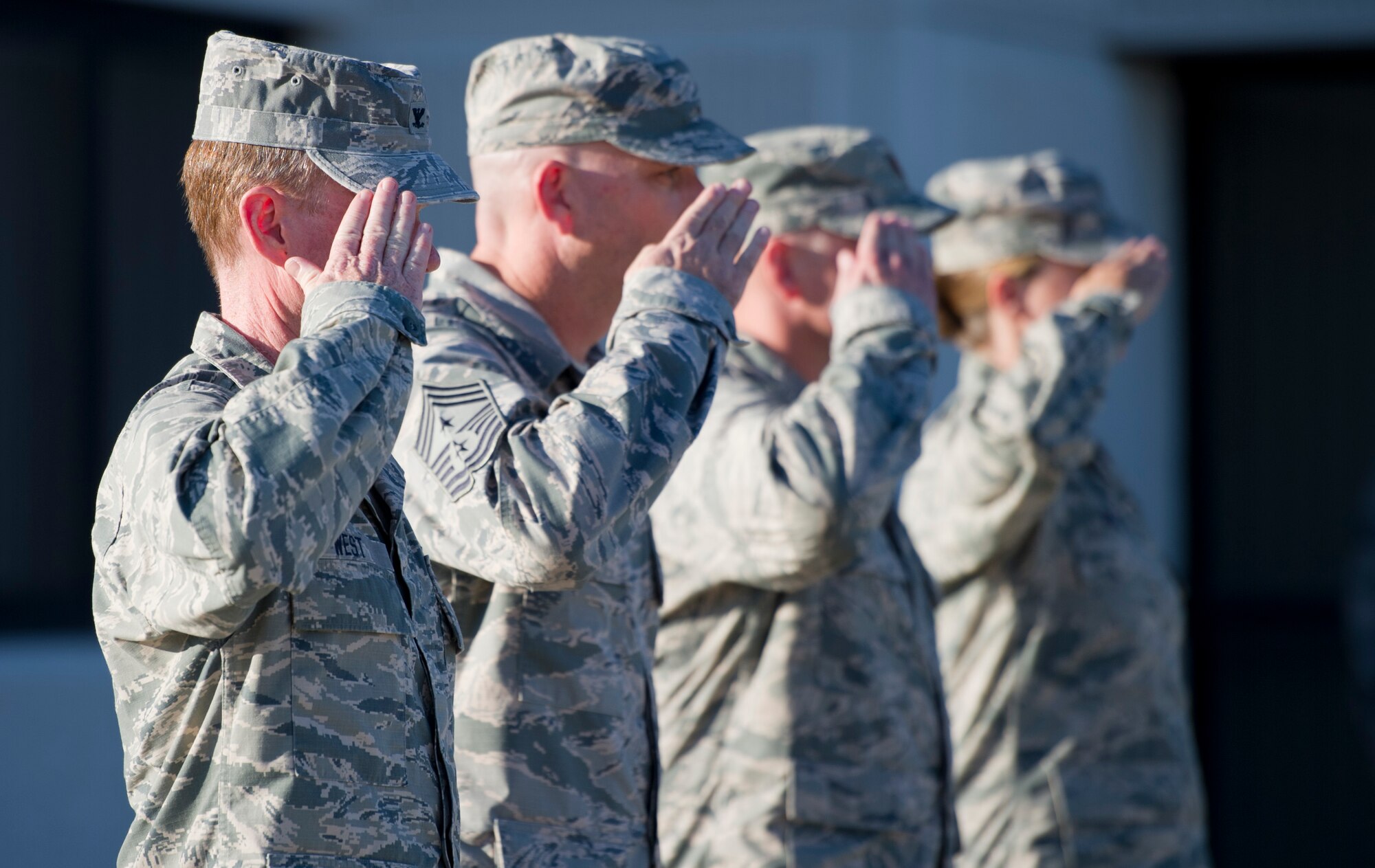 Leadership from the 1st Special Operations Wing salute as the United States flag is lowered during a retreat ceremony at Hurlburt Field, Fla., Oct. 8, 2014. The retreat ceremony serves a twofold purpose; it signals the end of the official duty day and serves as a ceremony for paying respect to the flag. (U.S. Air Force photo/Senior Airman Krystal M. Garrett)