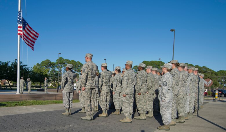 Airmen from the wing staff agencies salute the United States Flag as it is lowered during a retreat ceremony at Hurlburt Field, Fla., Oct. 8, 2014. The retreat ceremony serves a twofold purpose; it signals the end of the official duty day and serves as a ceremony for paying respect to the flag.  (U.S. Air Force photo/Senior Airman Krystal M. Garrett)