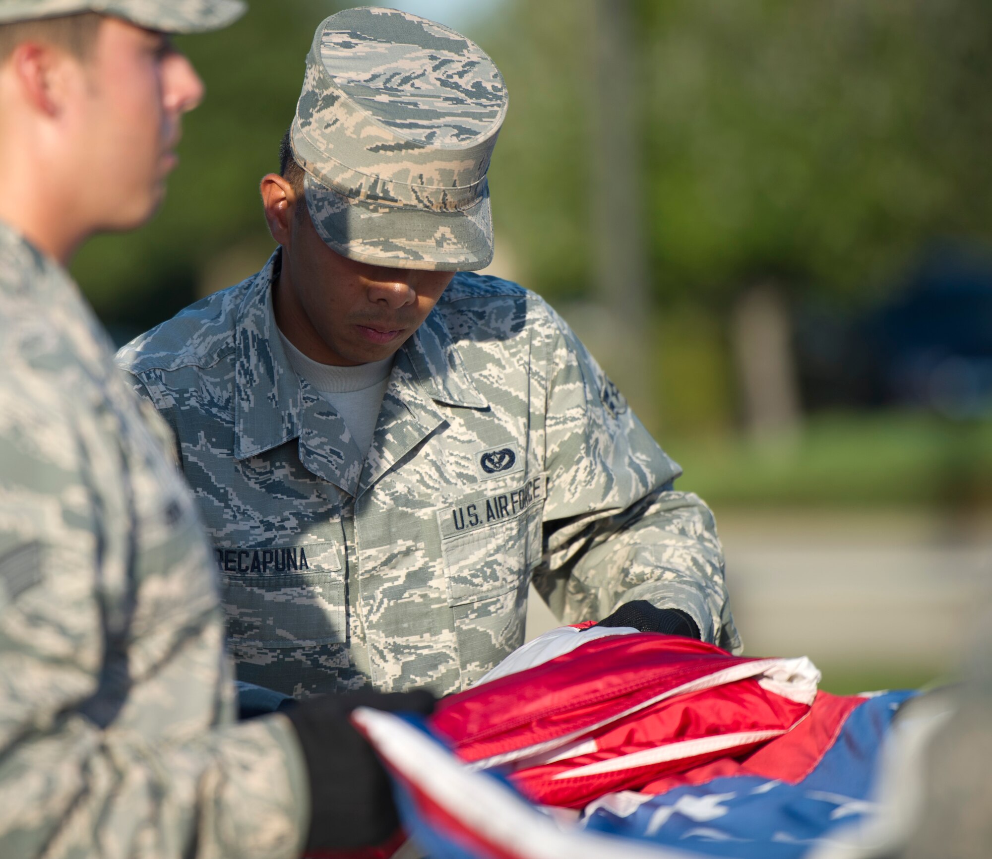 Airmen from the 1st Special Operations Wing Honor Guard fold the United States Flag during retreat ceremony at Hurlburt Field, Fla., Oct. 8, 2014. By giving the flag a distinctive fold, it shows respect to the flag and expresses gratitude to individuals who fought and continue to fight for freedom.  (U.S. Air Force photo/Senior Airman Krystal M. Garrett) 