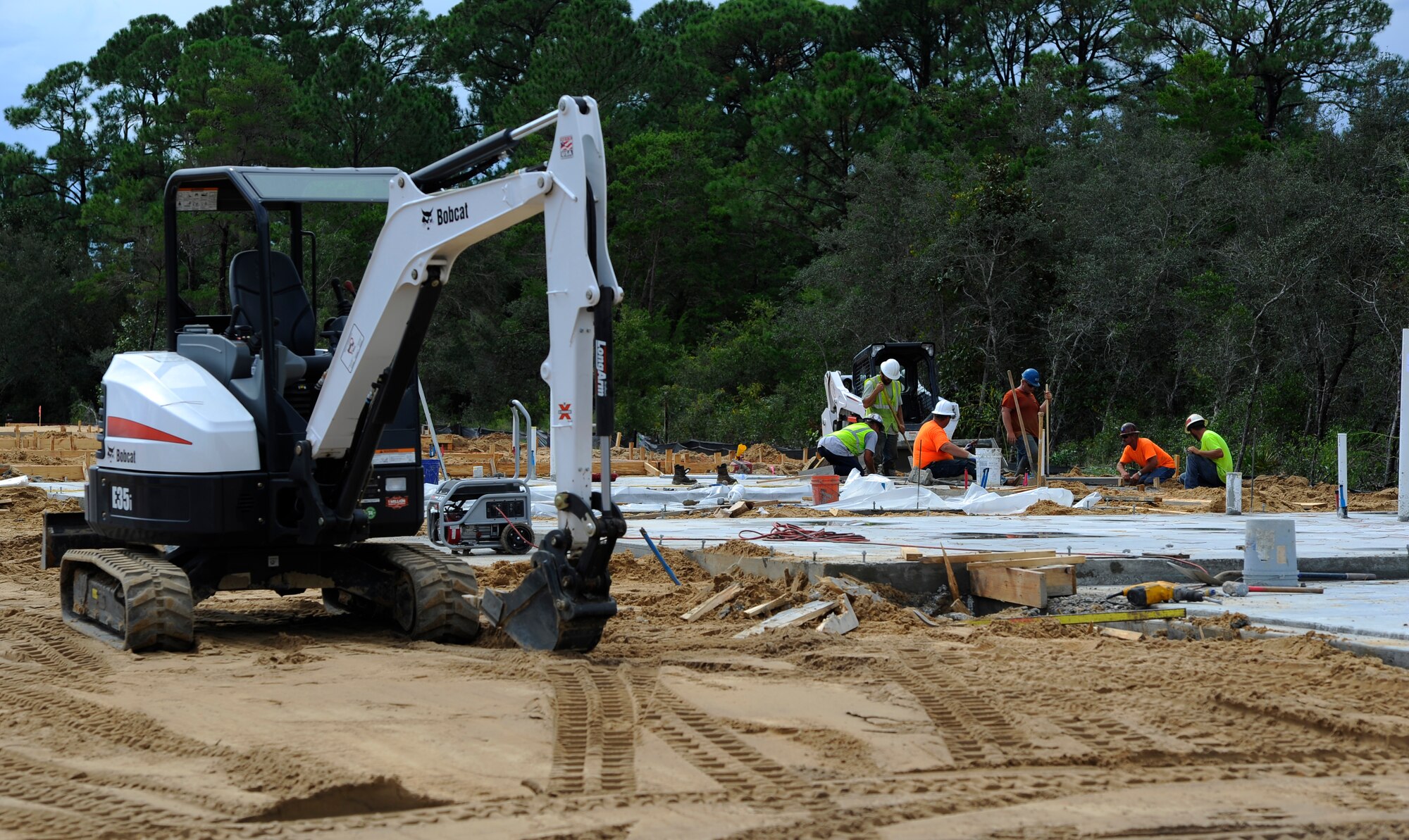 Construction workers work on a concrete pad for the future Osprey neighborhood on Hurlburt Field, Fla., Oct. 2, 2014. The concrete pads are the first step of vertical construction of the new homes. (U.S. Air Force photo/Staff Sgt. Sarah Hanson)