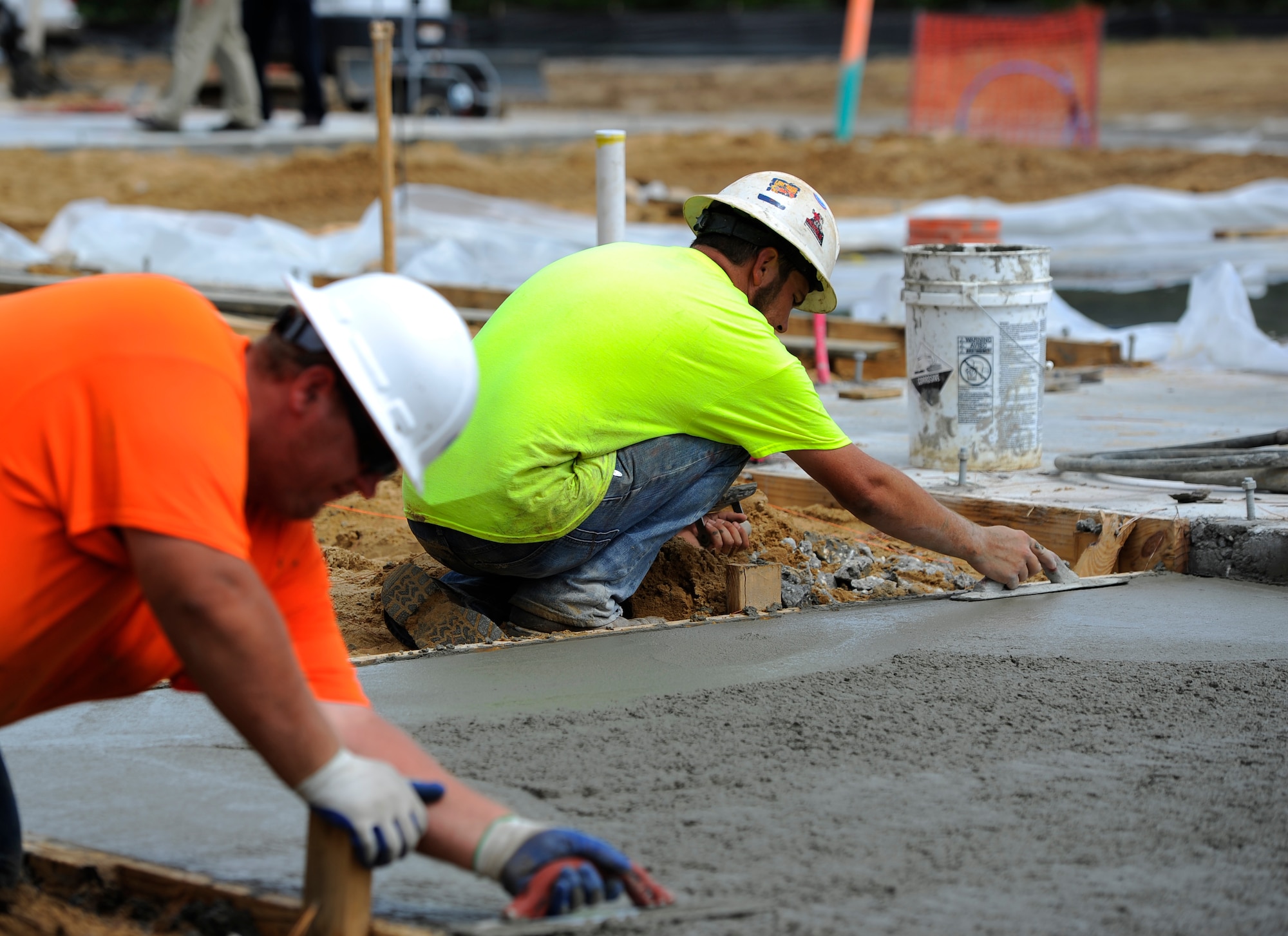 Construction workers use magnesium float tools to level the surface of poured concrete for the future Osprey neighborhood on Hurlburt Field, Fla., Oct. 2, 2014. The neighborhood will consist of 63 new single family homes for senior non-commissioned officers and chief master sergeants. (U.S. Air Force photo/Staff Sgt. Sarah Hanson)